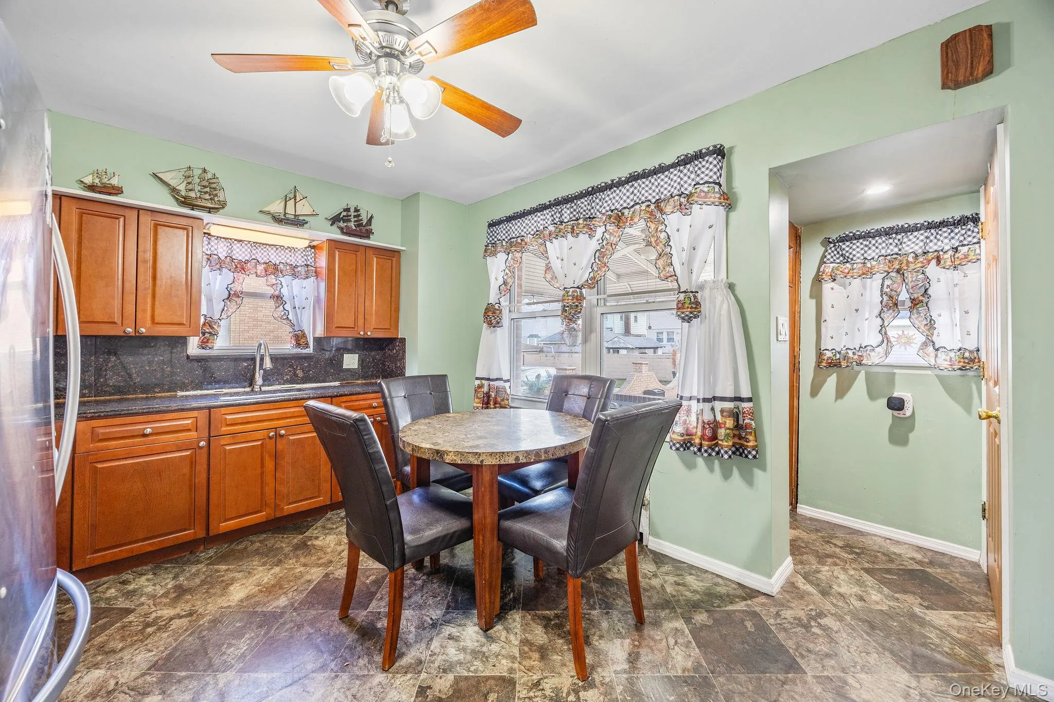 Dining area with healthy amount of natural light, stone finish flooring, and ceiling fan Dining area with healthy amount of natural light, stone finish flooring, and ceiling fan