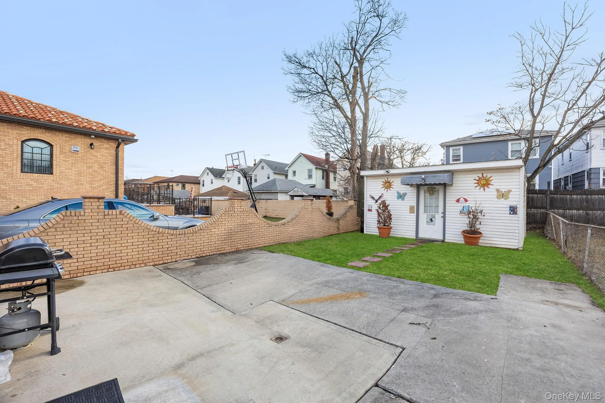 Fenced backyard with a patio area, area for grilling, and a residential view Fenced backyard with a patio area, area for grilling, and a residential view