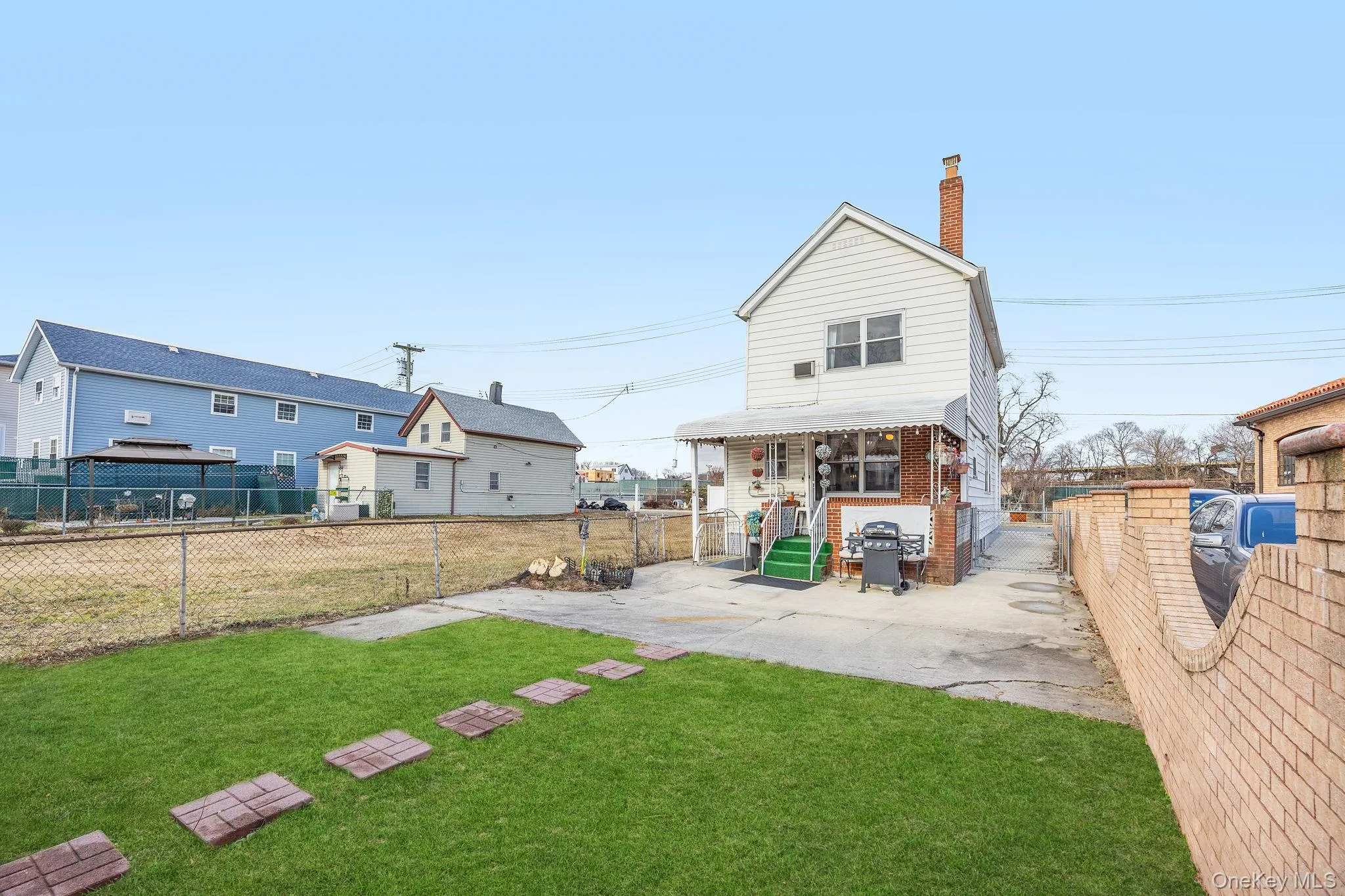 Rear view of property with a fenced backyard, a chimney, and a gate Rear view of property with a fenced backyard, a chimney, and a gate