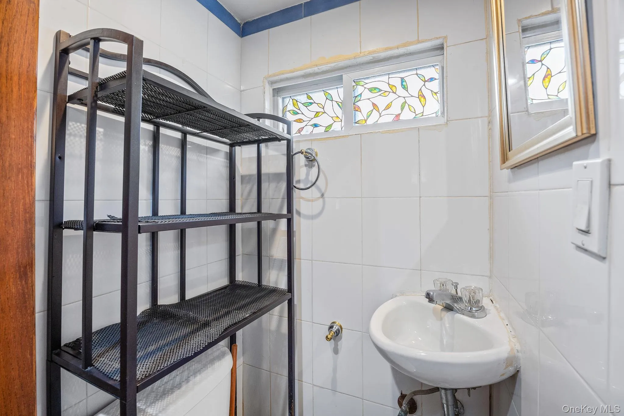 Half bathroom featuring a sink and tile walls Half bathroom featuring a sink and tile walls