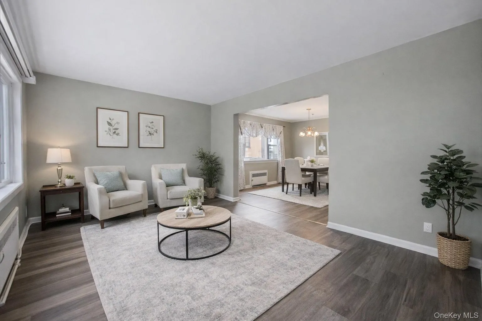 Living room with dark wood-style flooring and a chandelier Living room with dark wood-style flooring and a chandelier