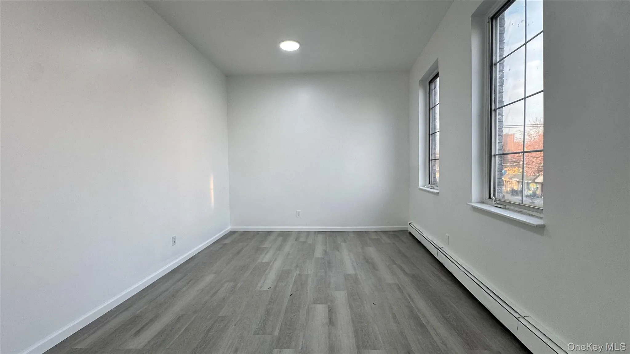 Empty room featuring a baseboard radiator, light wood finished floors, and recessed lighting Empty room featuring a baseboard radiator, light wood finished floors, and recessed lighting
