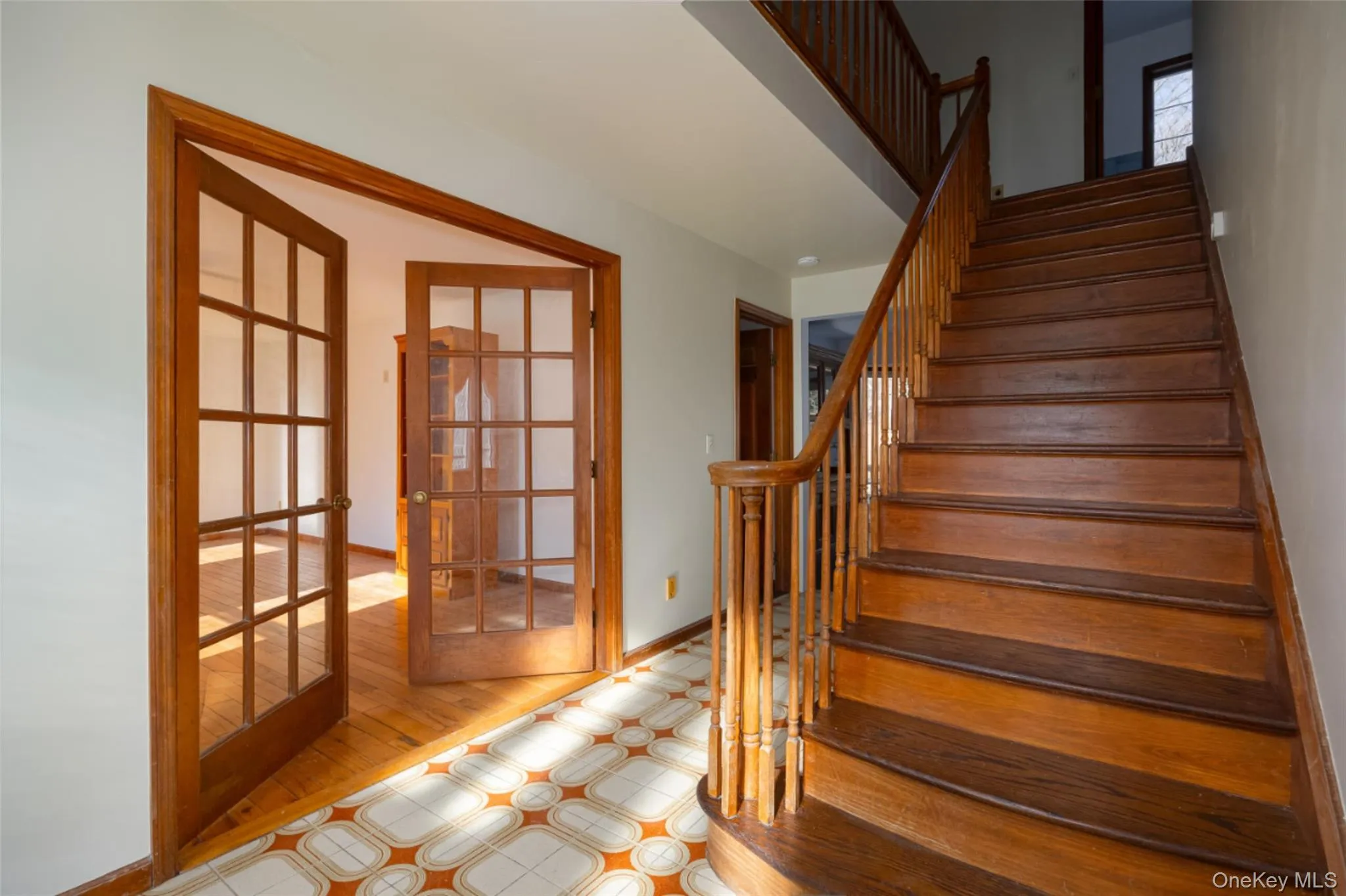 Staircase featuring French doors and tile floors Staircase featuring French doors and tile floors
