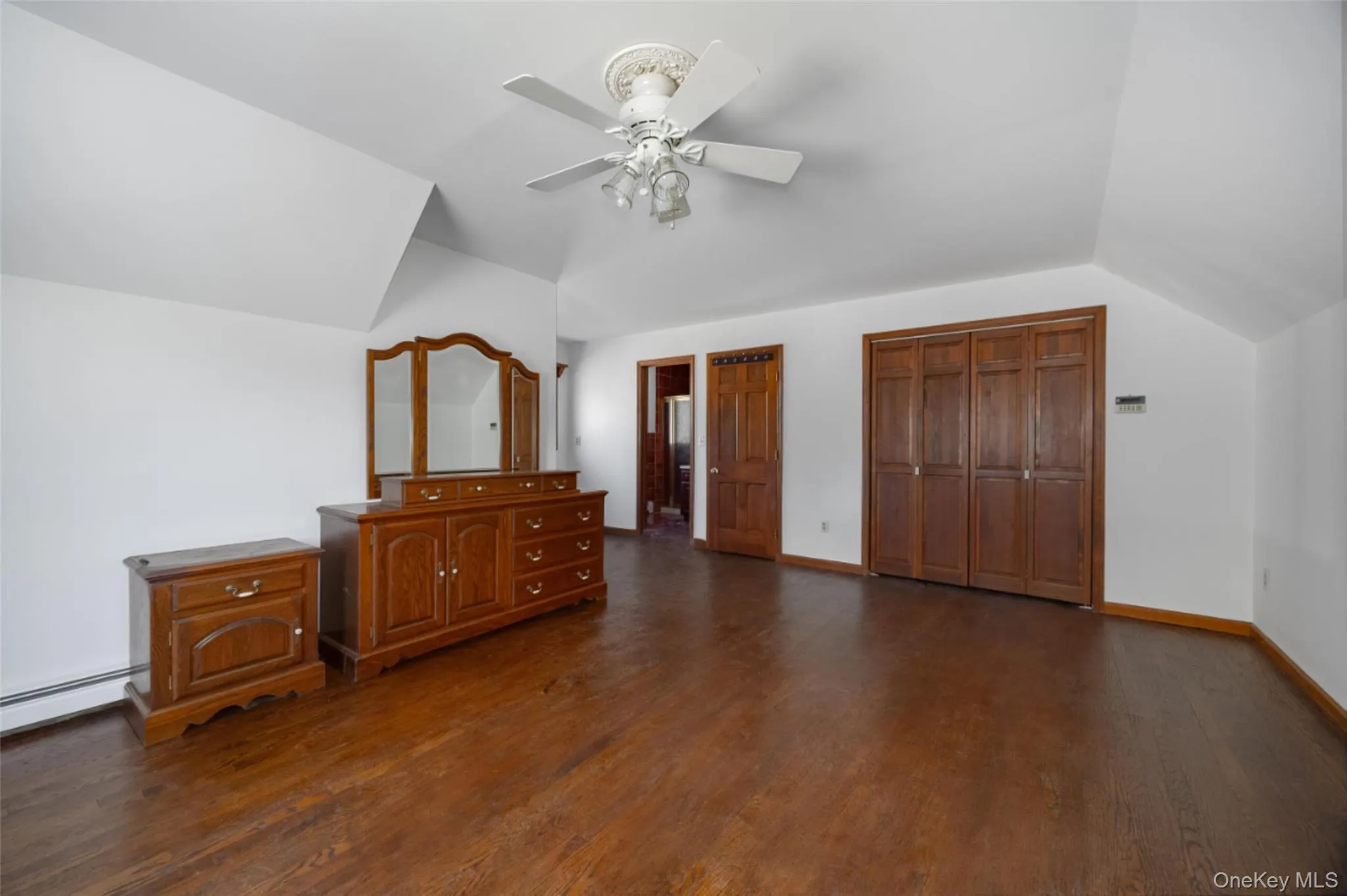 Bedroom 3 featuring vaulted ceiling, wood floors, ceiling fan, two closets, and ensuite bathroom Bedroom 3 featuring vaulted ceiling, wood floors, ceiling fan, two closets, and ensuite bathroom