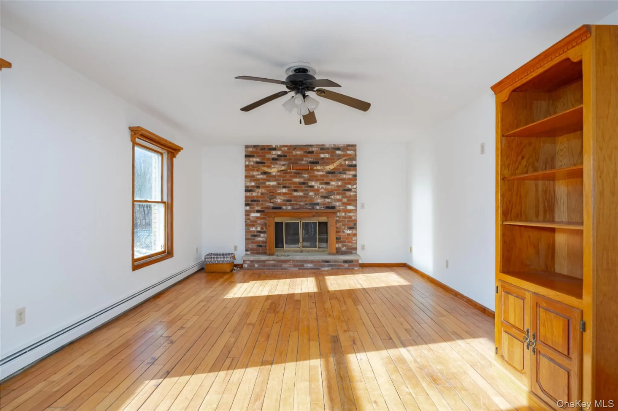 Unfurnished living room featuring a fireplace, light wood finished floors, and ceiling fan Unfurnished living room featuring a fireplace, light wood finished floors, and ceiling fan