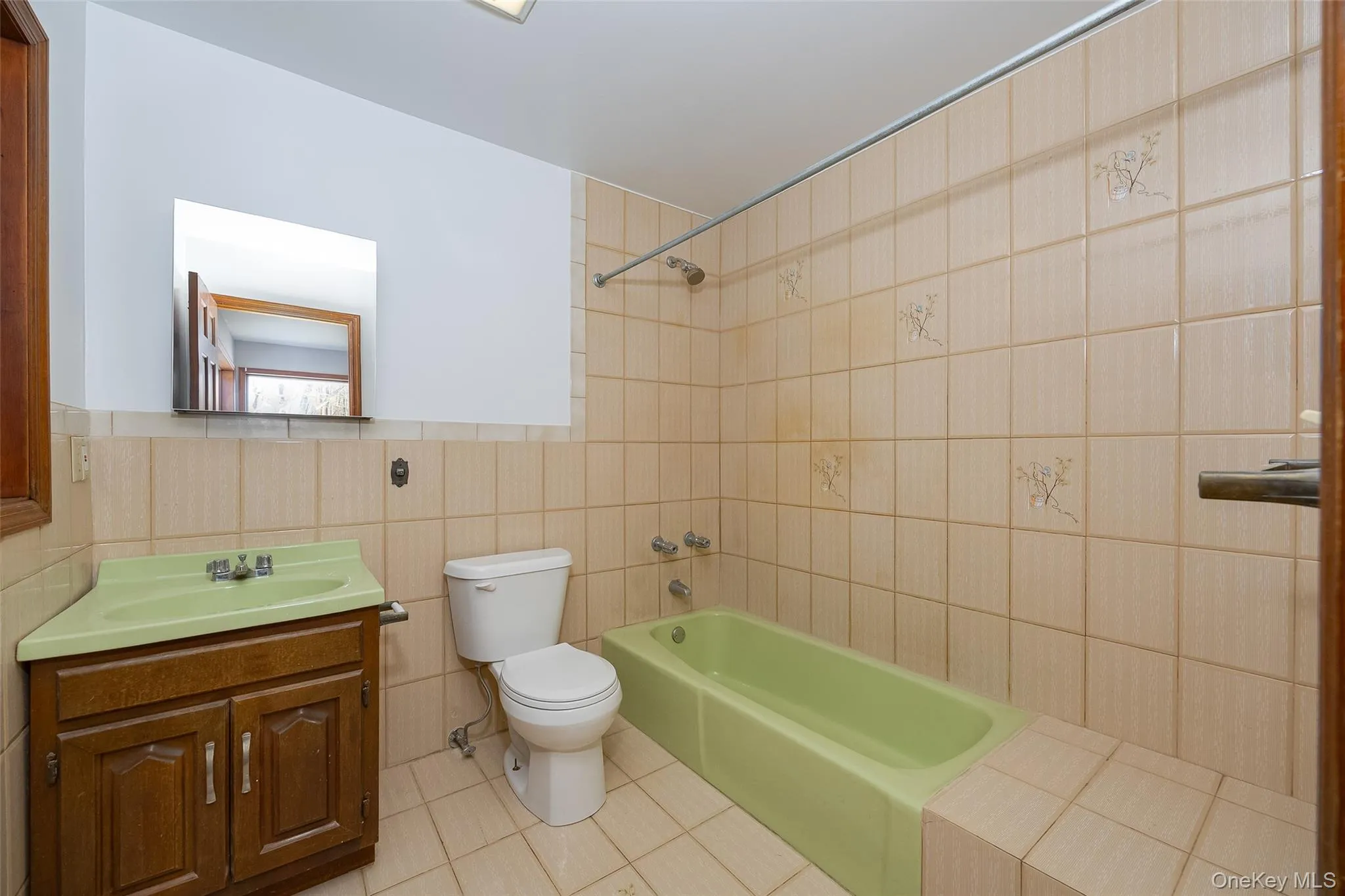 Full first floor bathroom with vanity, bathtub / shower combination, and light tile floors Full first floor bathroom with vanity, bathtub / shower combination, and light tile floors