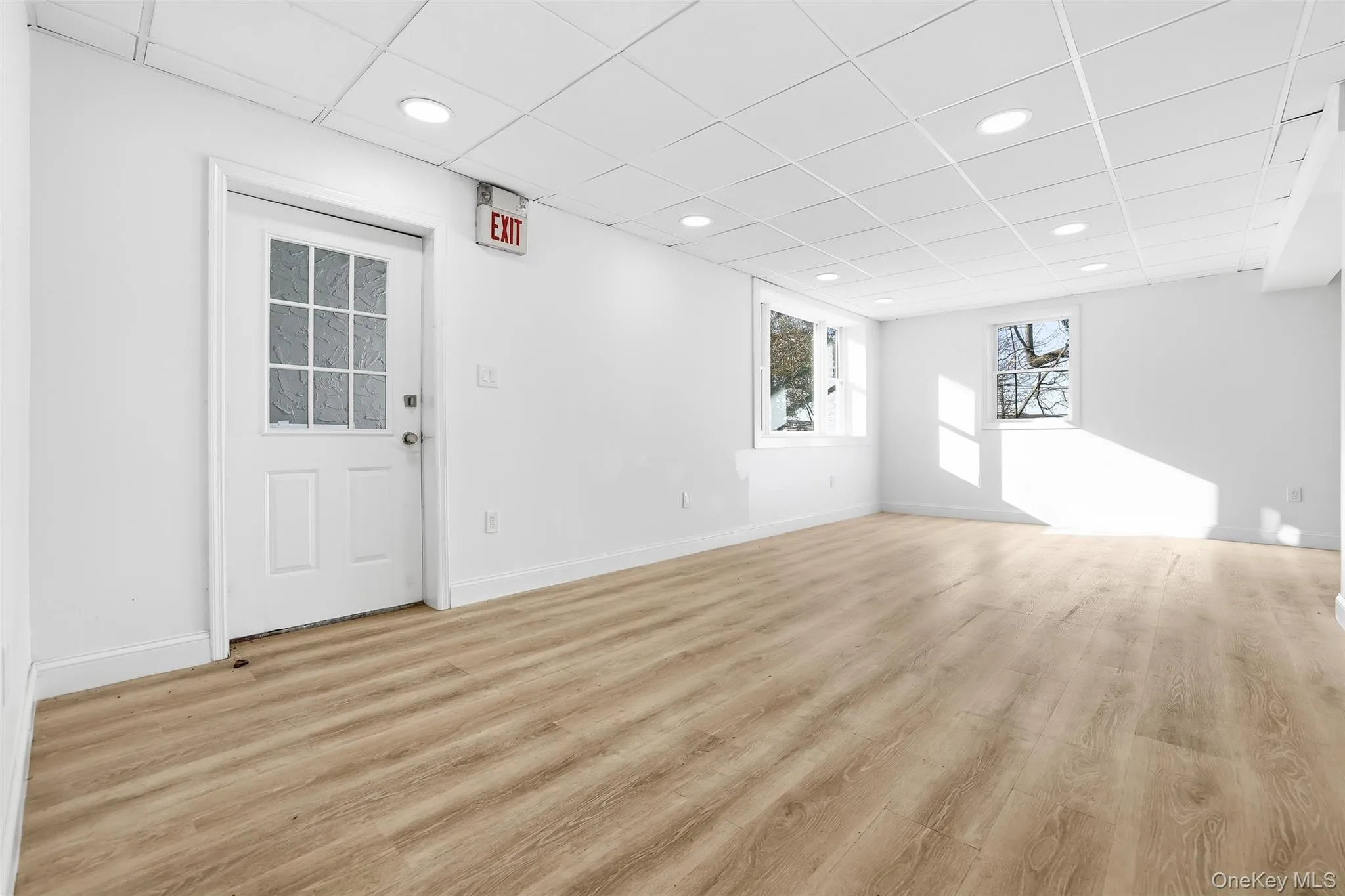 Empty room featuring a drop ceiling, light wood-style flooring, and recessed lighting Empty room featuring a drop ceiling, light wood-style flooring, and recessed lighting
