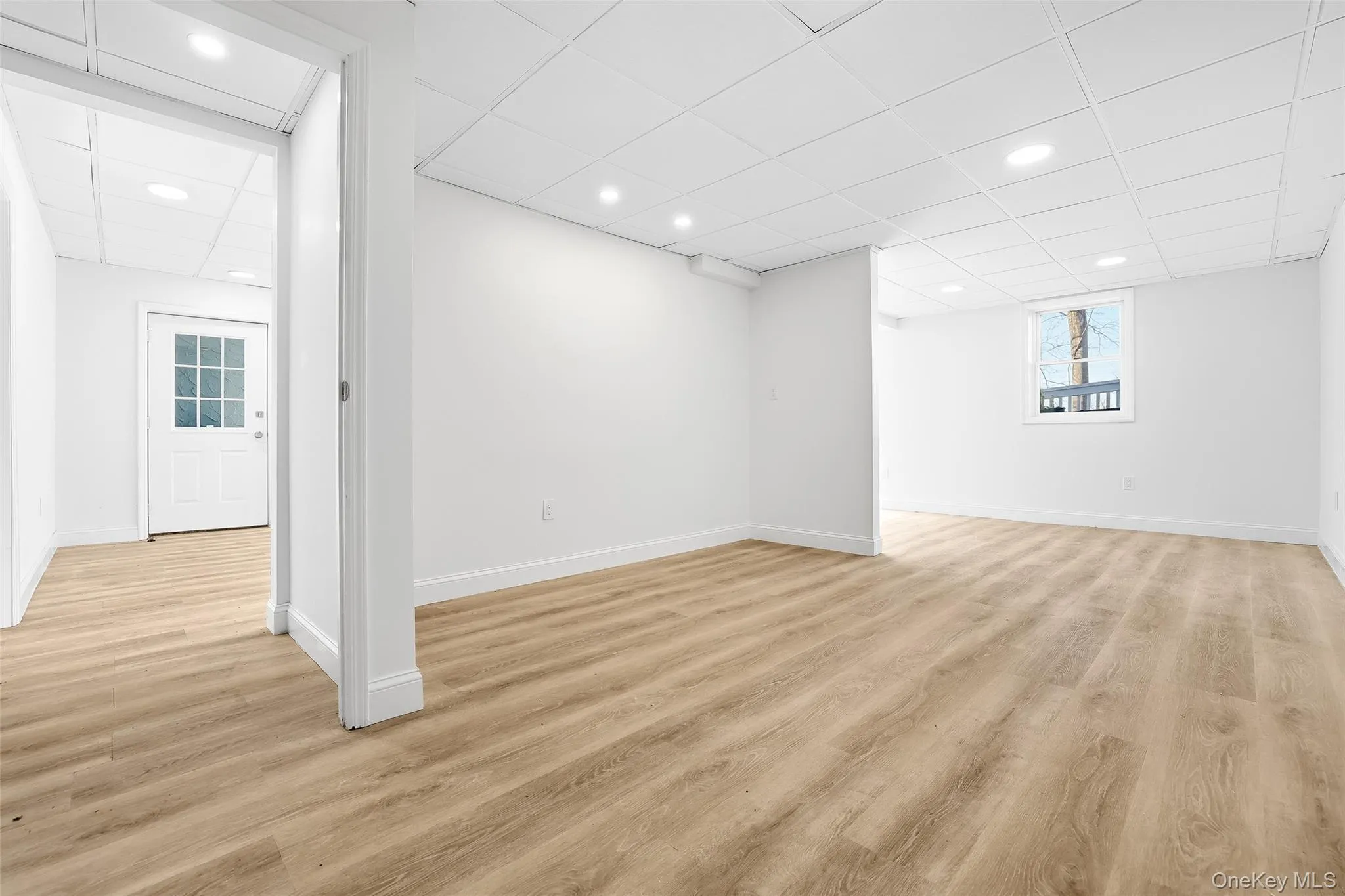 Below grade area featuring a drop ceiling, light wood-style floors, and recessed lighting Below grade area featuring a drop ceiling, light wood-style floors, and recessed lighting