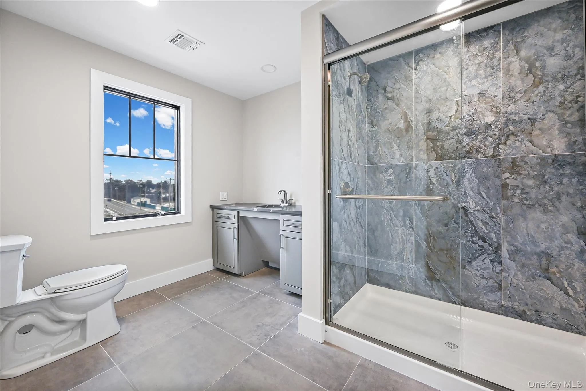 Bathroom with vanity, a shower stall, light tile patterned floors, and recessed lighting Bathroom with vanity, a shower stall, light tile patterned floors, and recessed lighting