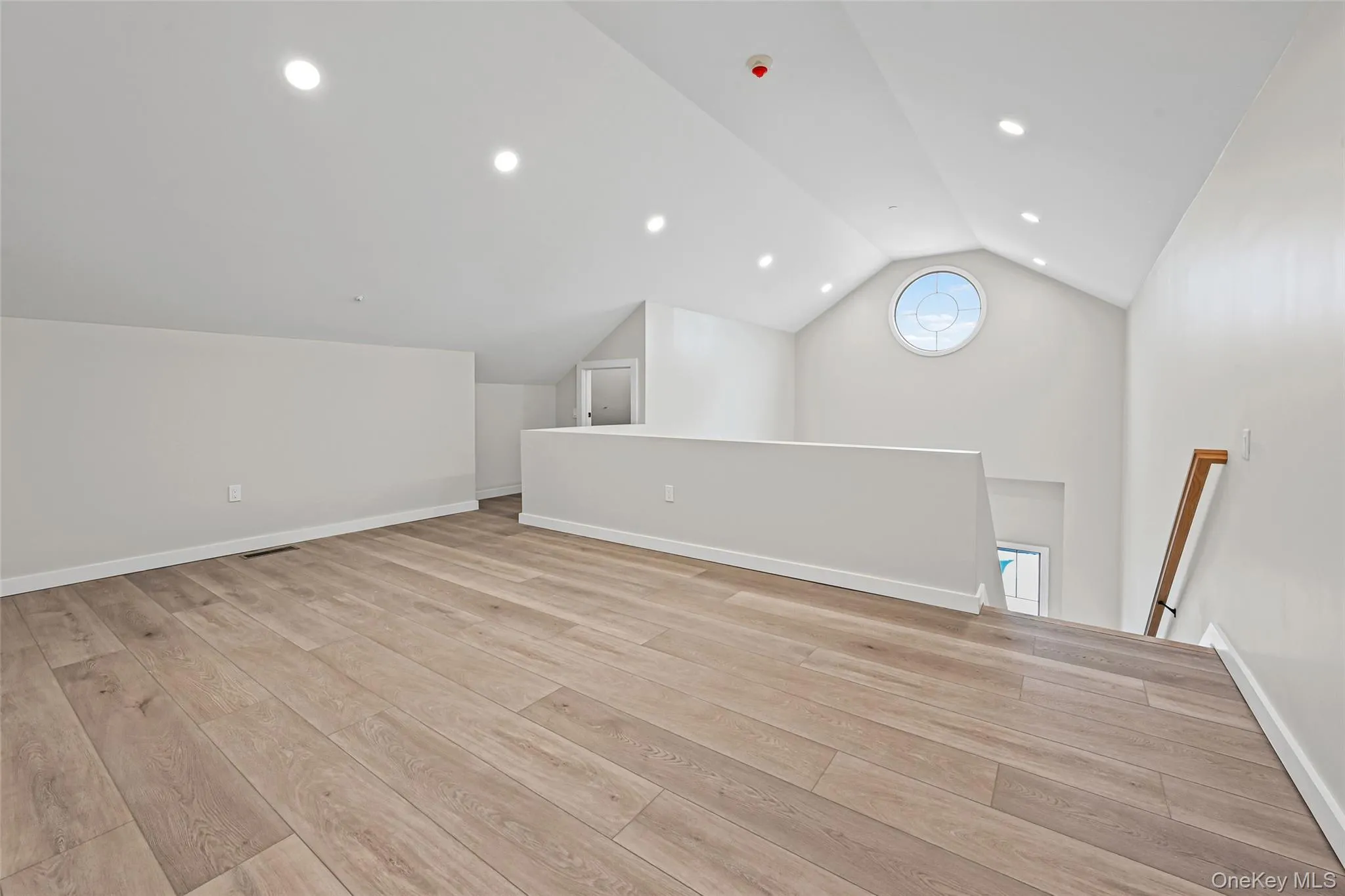 Additional living space with vaulted ceiling, recessed lighting, and light wood-type flooring Additional living space with vaulted ceiling, recessed lighting, and light wood-type flooring