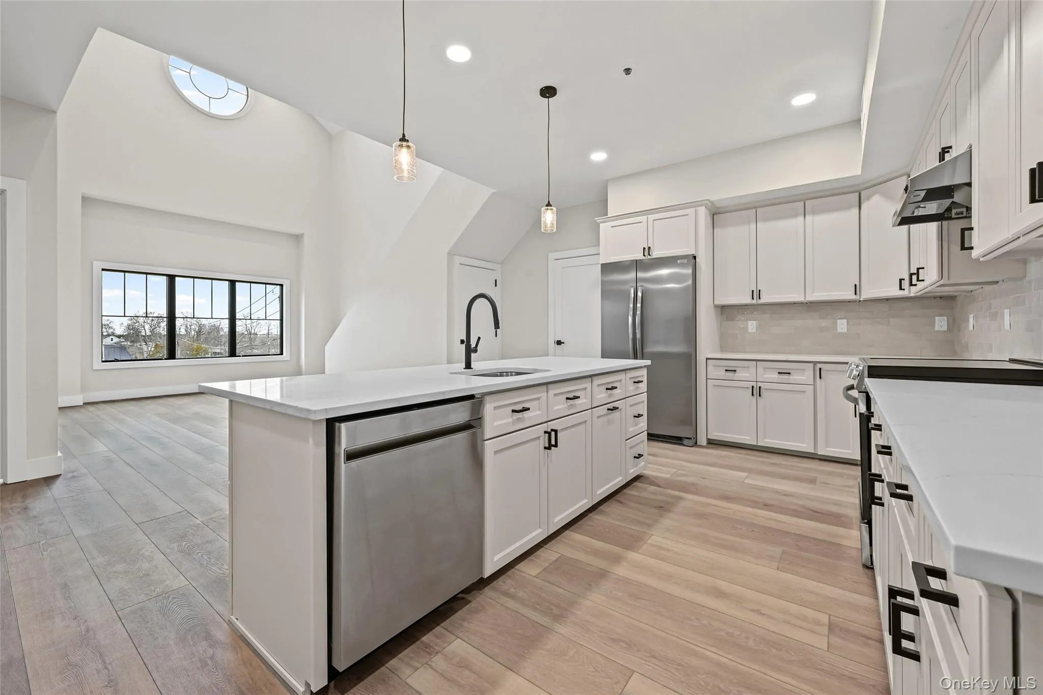 Kitchen featuring tasteful backsplash, appliances with stainless steel finishes, white cabinetry, and recessed lighting Kitchen featuring tasteful backsplash, appliances with stainless steel finishes, white cabinetry, and recessed lighting