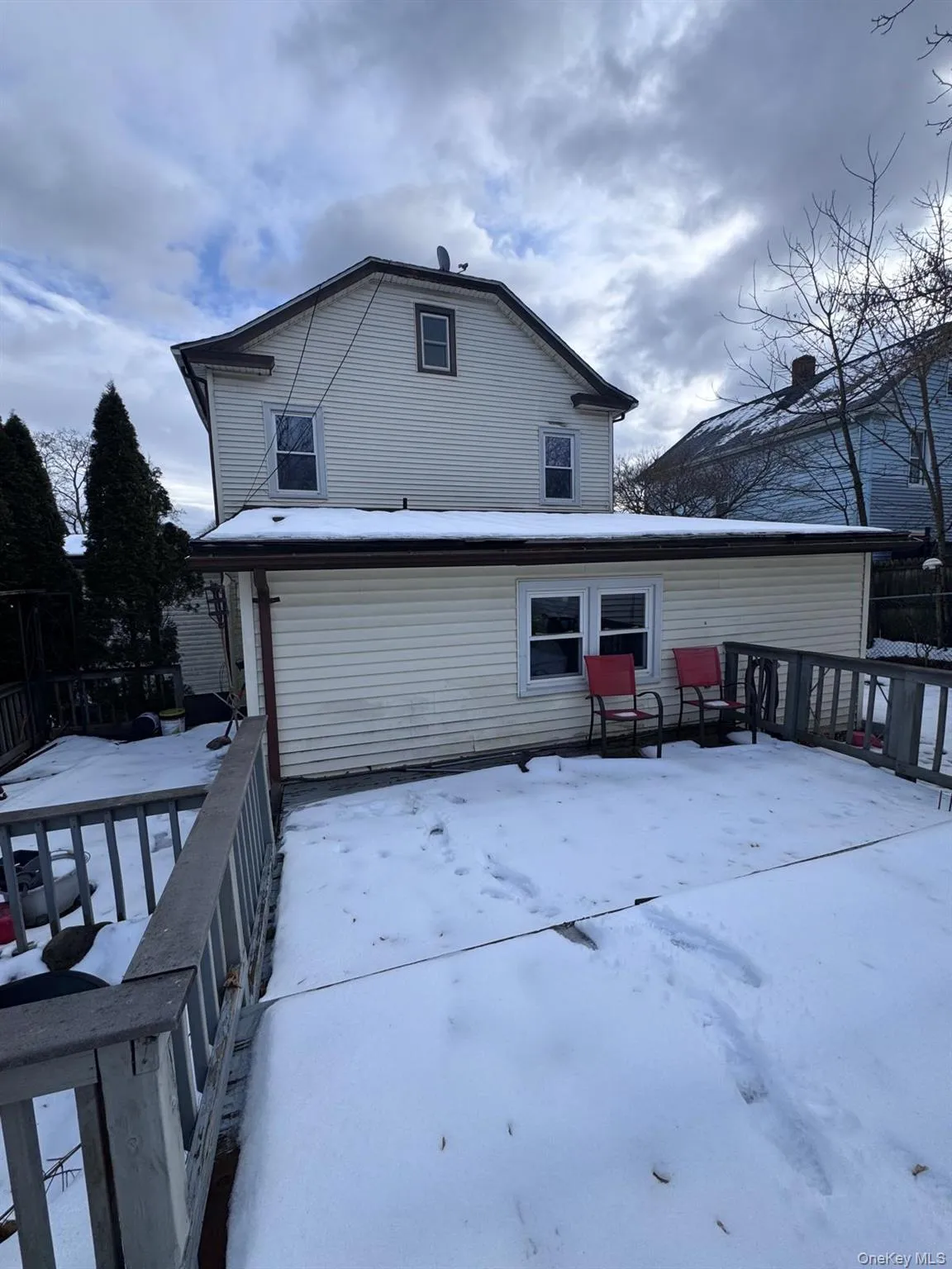 Snow covered rear of property with a wooden deck Snow covered rear of property with a wooden deck