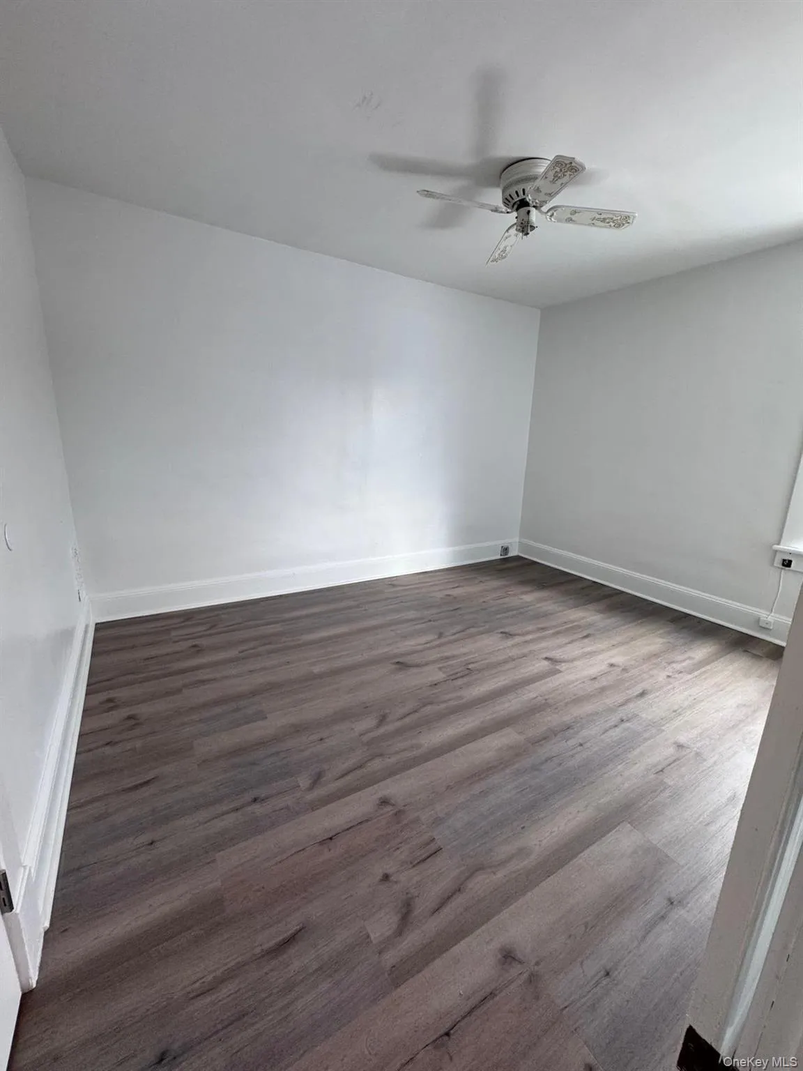 Unfurnished room with wood finished floors and ceiling fan Unfurnished room with wood finished floors and ceiling fan