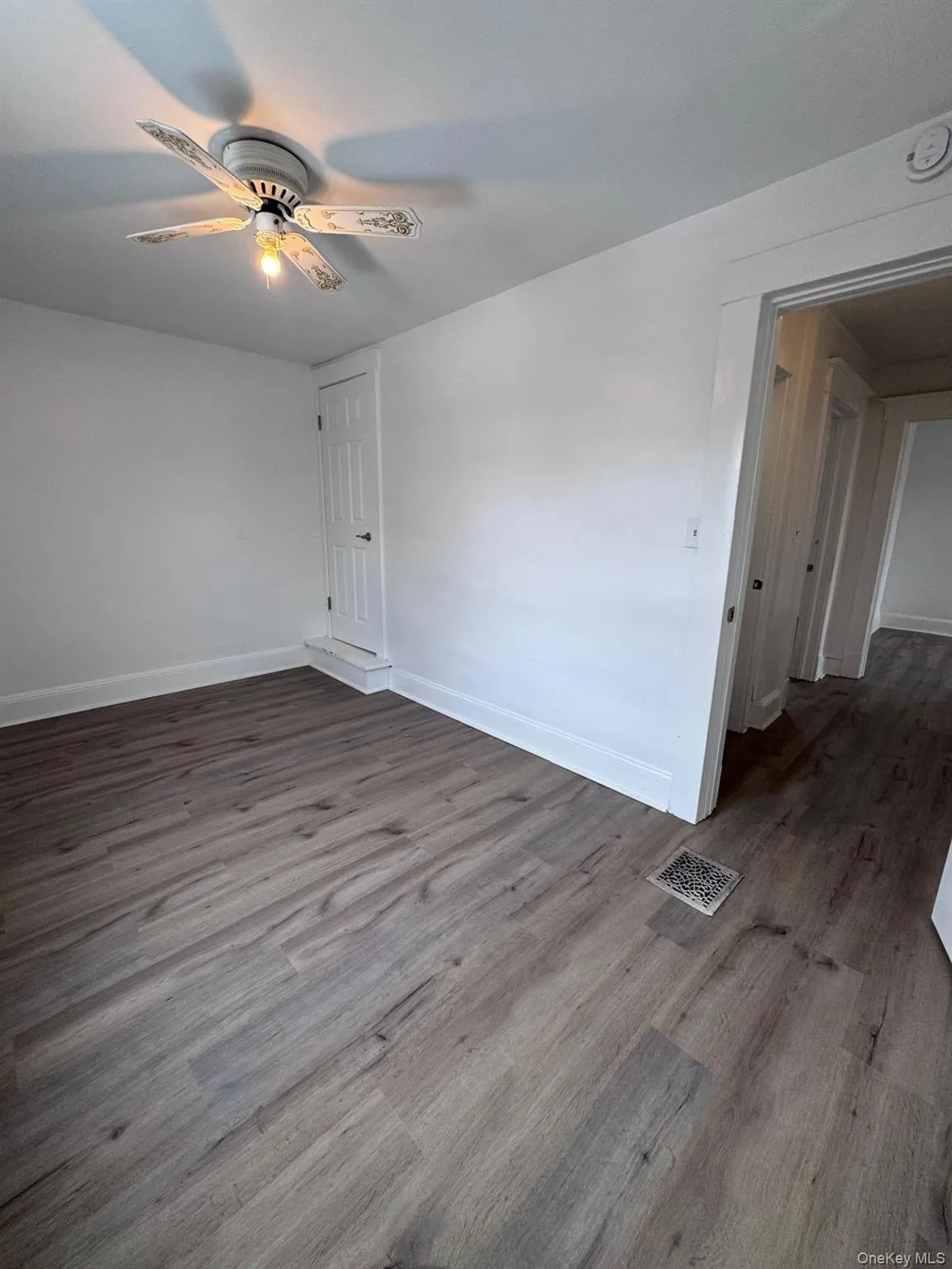 Spare room featuring dark wood-style floors and a ceiling fan Spare room featuring dark wood-style floors and a ceiling fan