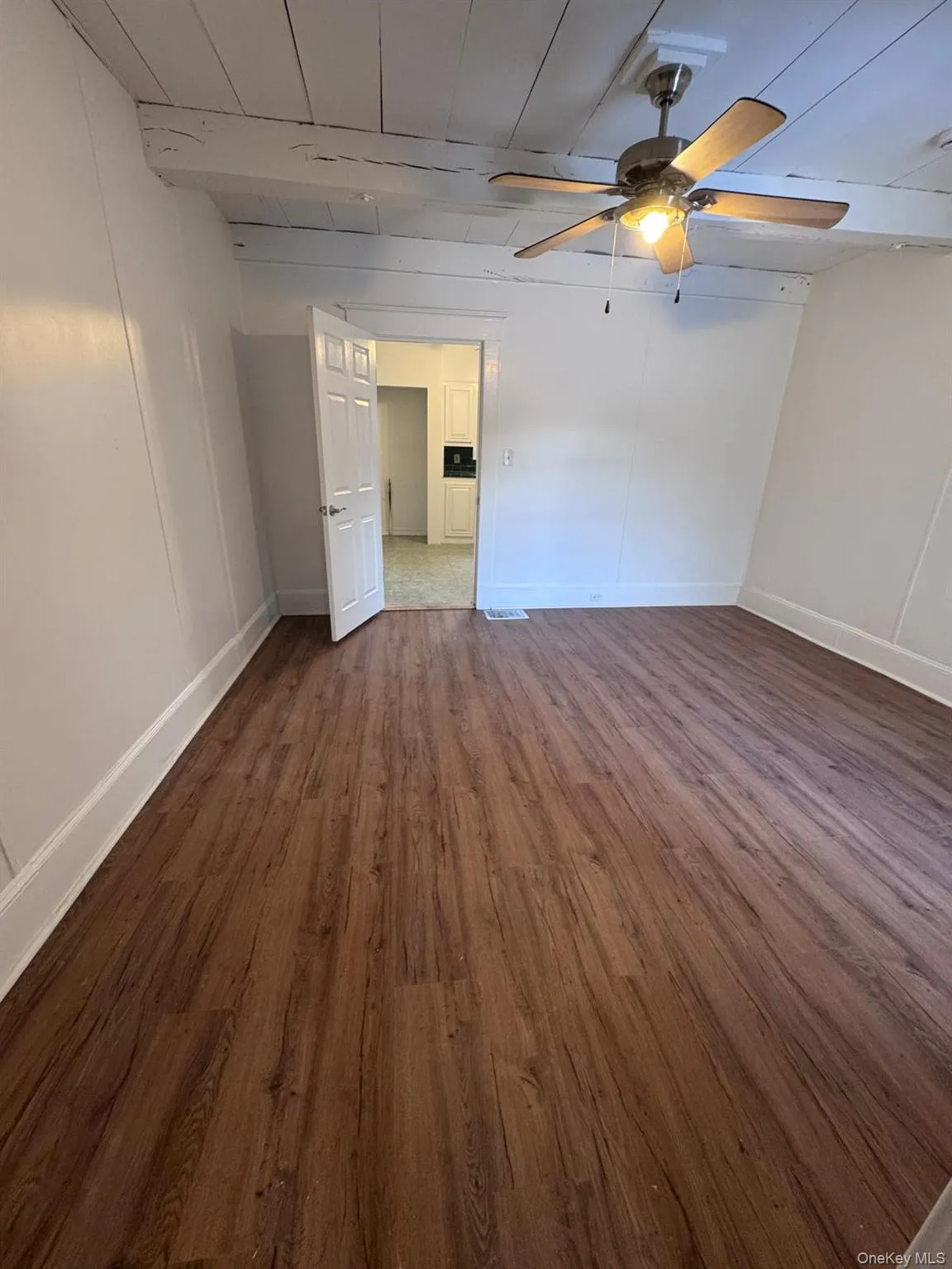 Spare room featuring dark wood finished floors and ceiling fan Spare room featuring dark wood finished floors and ceiling fan