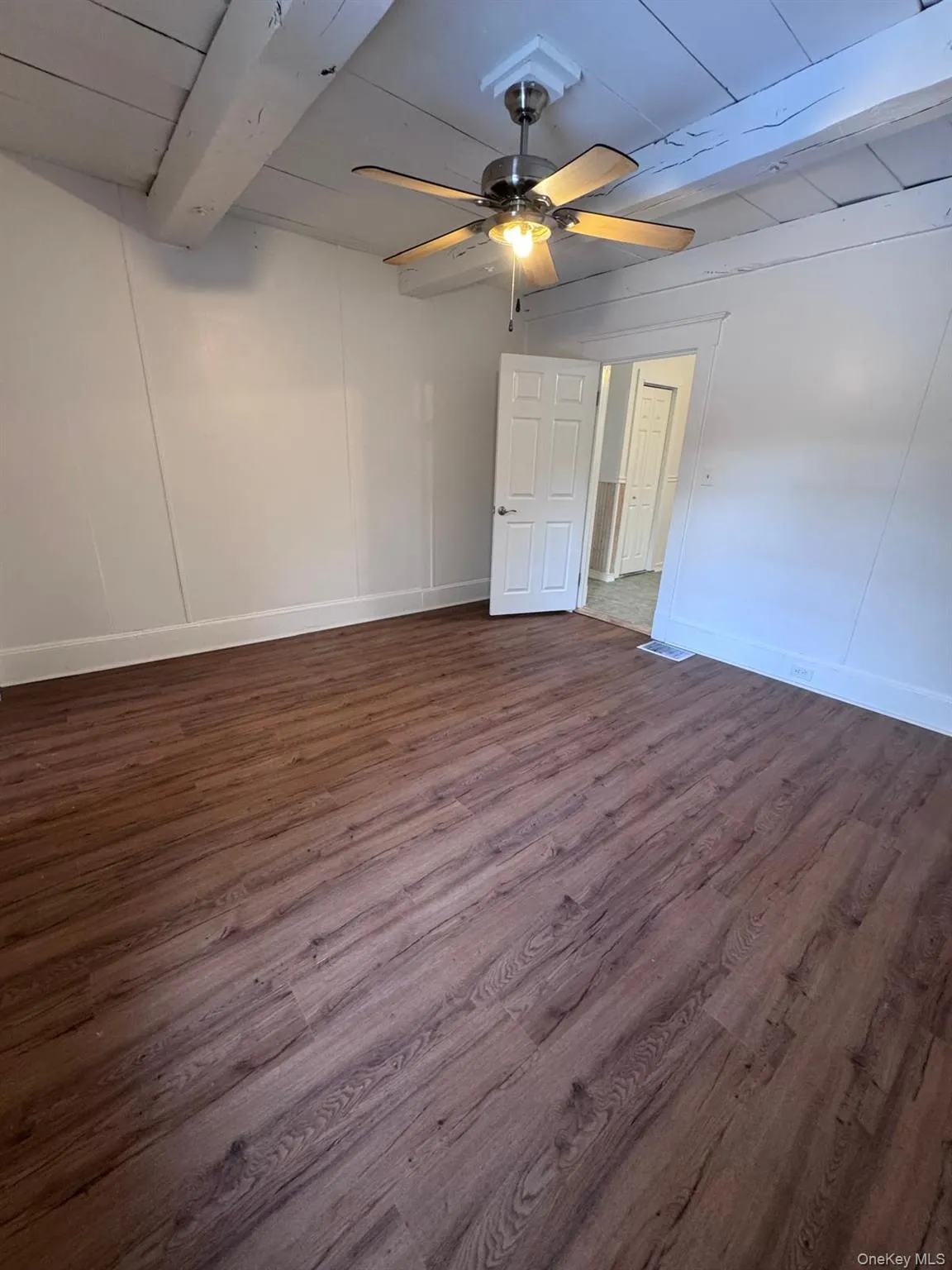 Unfurnished room with dark wood finished floors, ceiling fan, and a wooden ceiling with exposed beams Unfurnished room with dark wood finished floors, ceiling fan, and a wooden ceiling with exposed beams