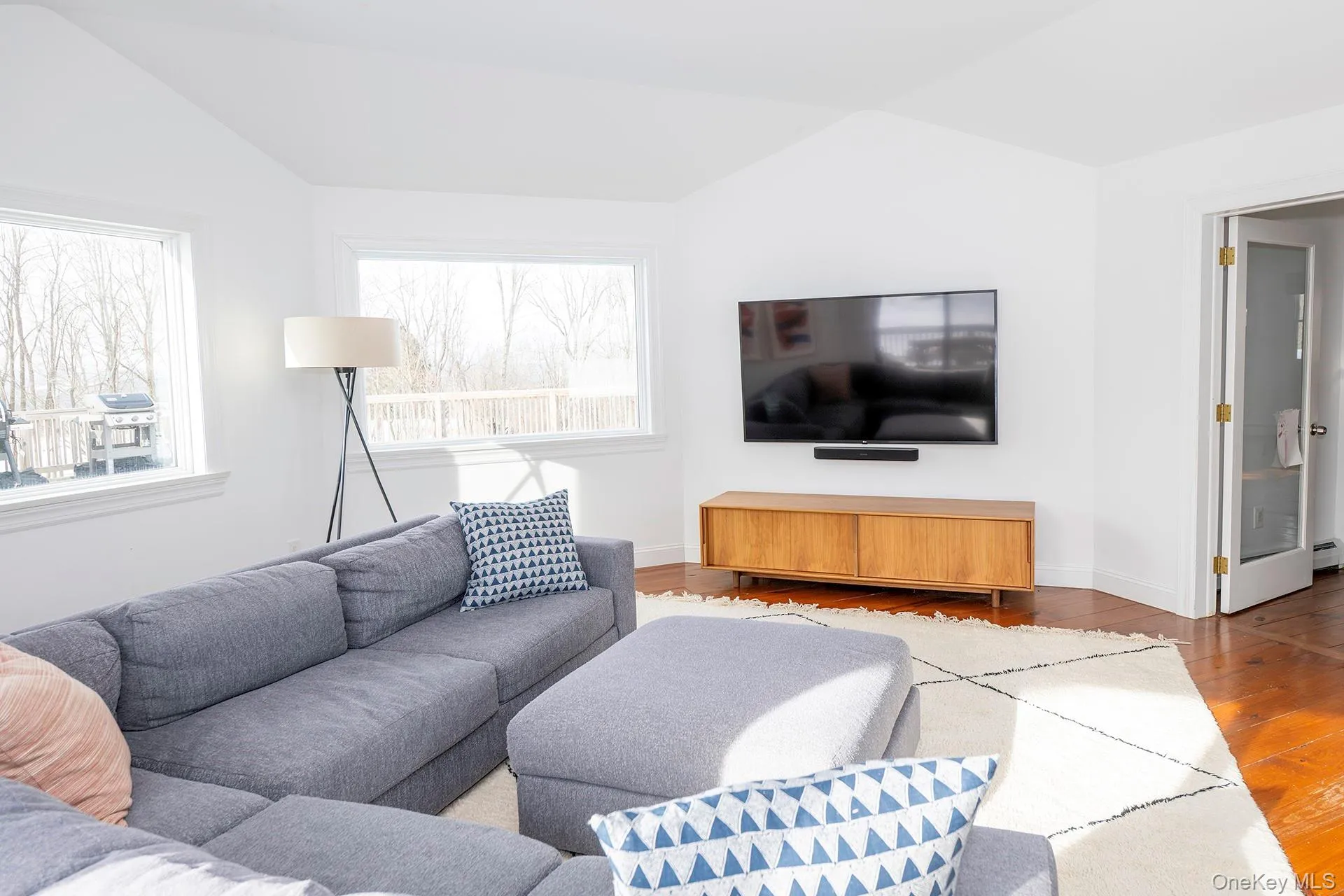 Living area with vaulted ceiling and wood-type flooring Living area with vaulted ceiling and wood-type flooring