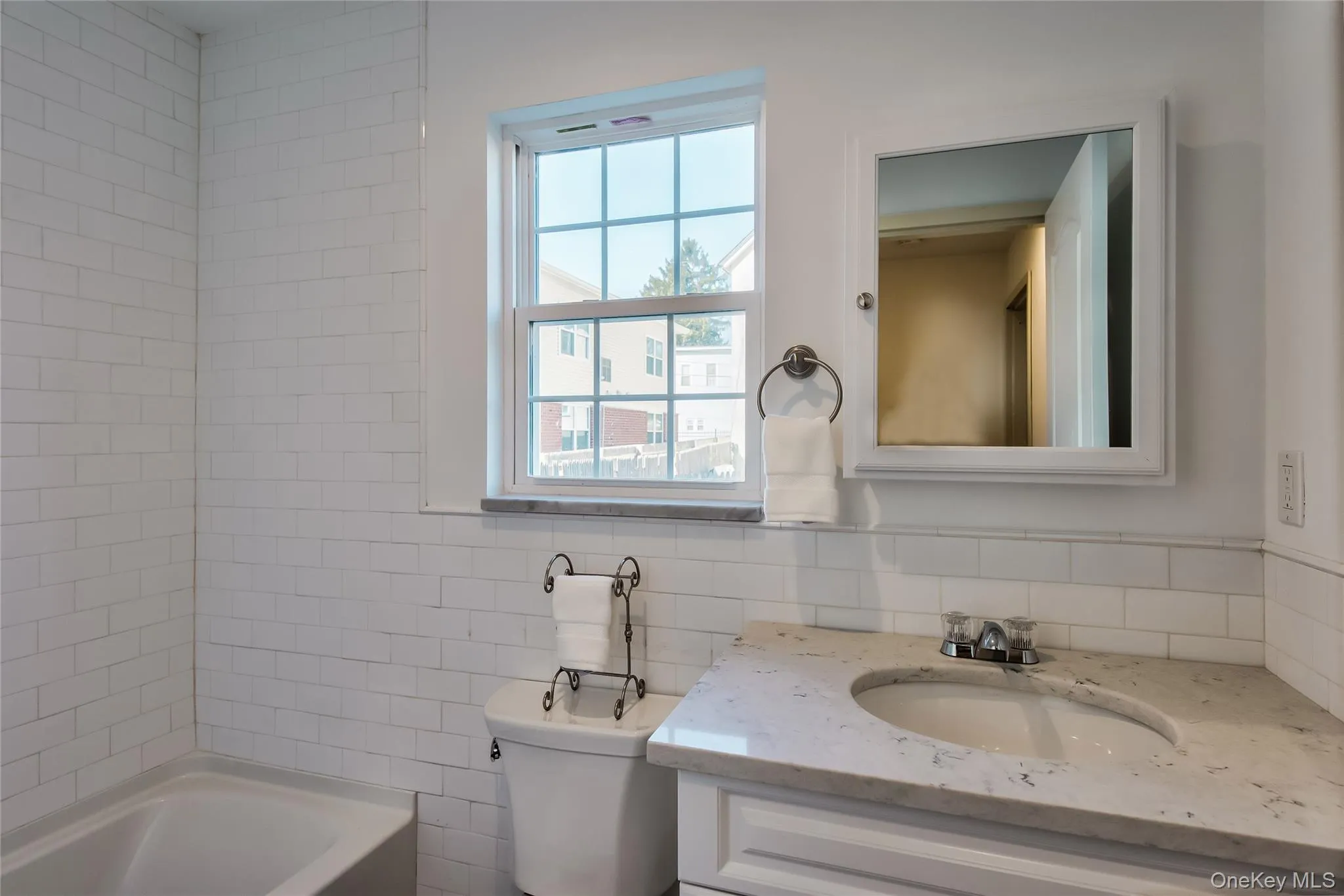 Full bath with tile walls, vanity, and shower / washtub combination Full bath with tile walls, vanity, and shower / washtub combination