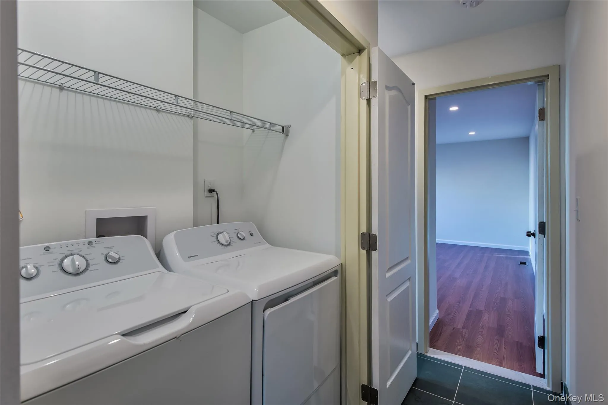 Laundry area with washing machine and dryer, dark tile patterned floors, and recessed lighting Laundry area with washing machine and dryer, dark tile patterned floors, and recessed lighting