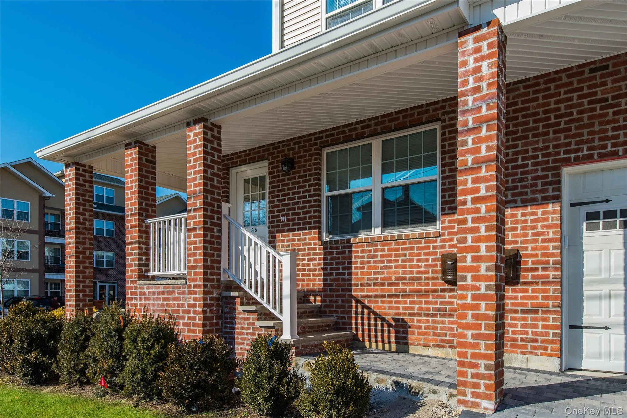View of exterior entry featuring a porch, brick siding, and a garage View of exterior entry featuring a porch, brick siding, and a garage
