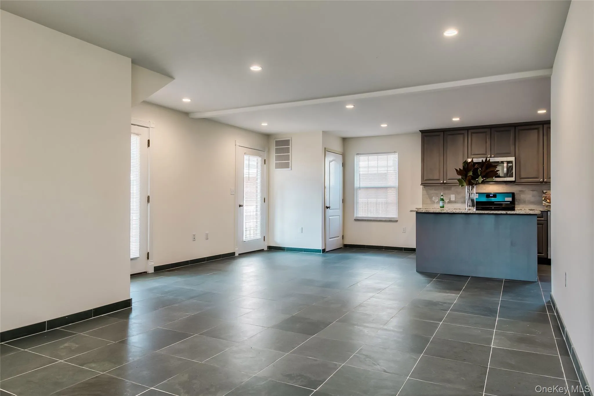 Kitchen featuring stainless steel microwave, black range oven, decorative backsplash, recessed lighting, and a center island Kitchen featuring stainless steel microwave, black range oven, decorative backsplash, recessed lighting, and a center island
