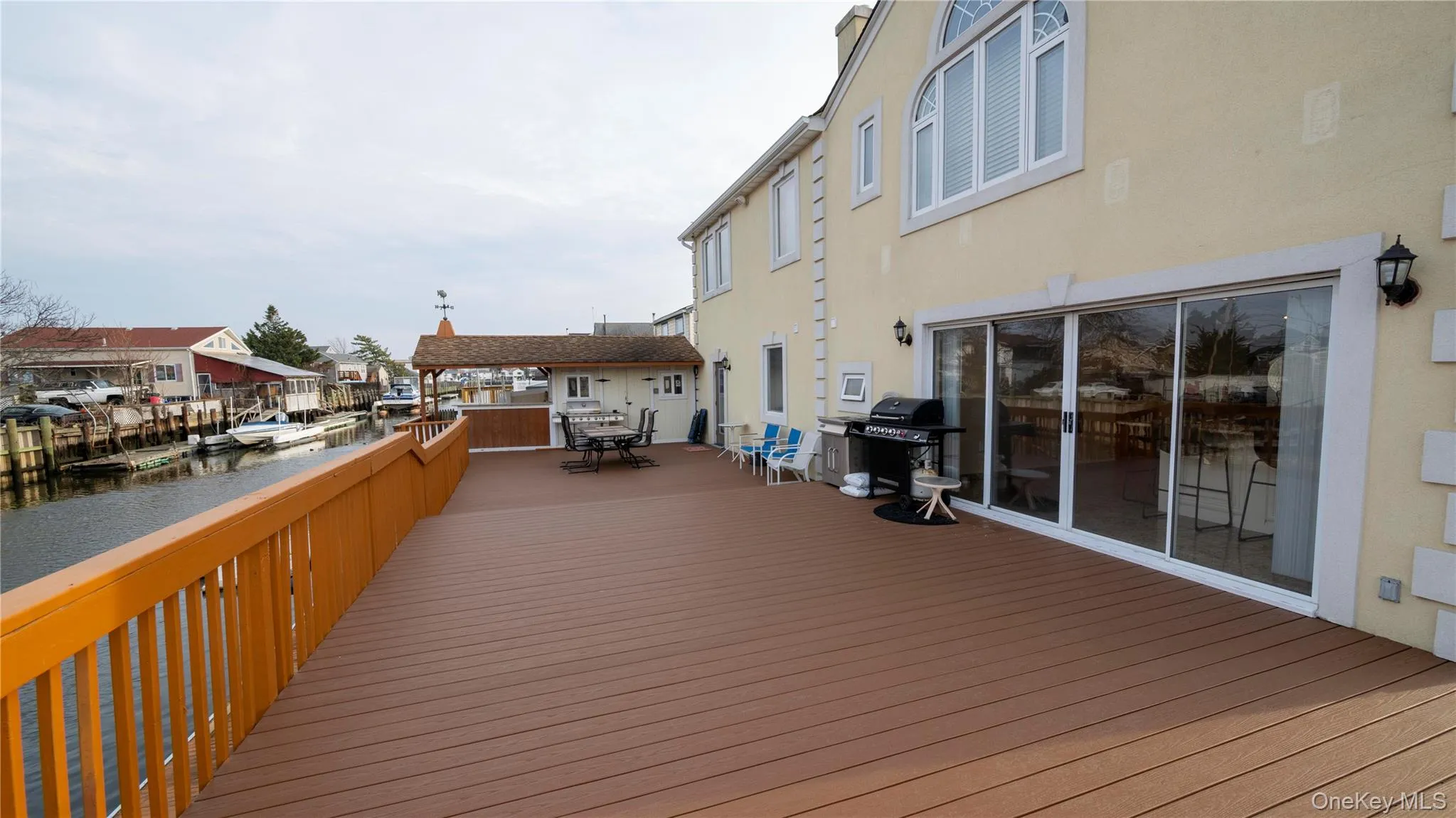 Deck featuring outdoor dining area, a water view, and a grill Deck featuring outdoor dining area, a water view, and a grill