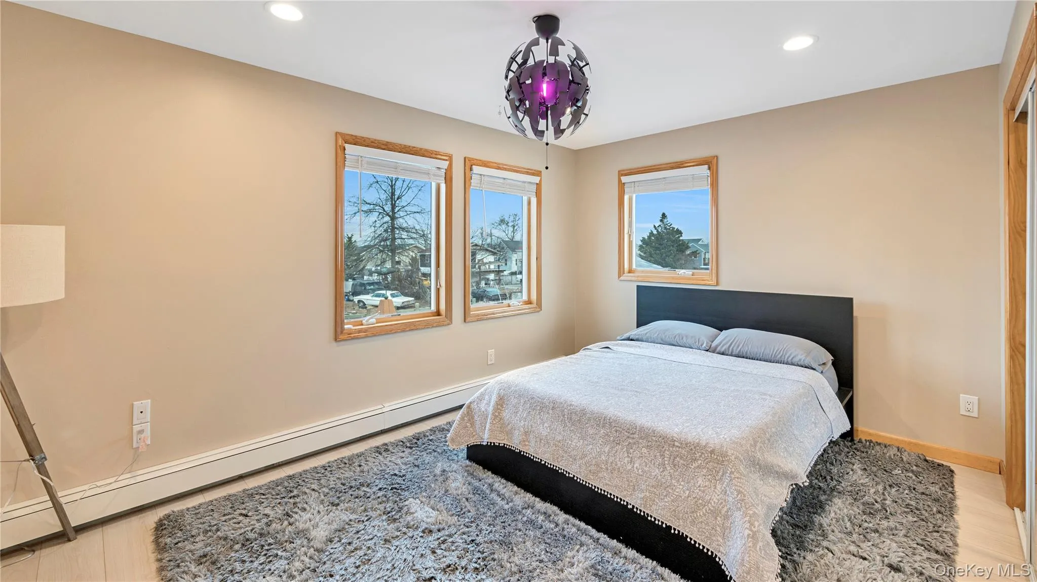 Bedroom featuring baseboard heating, recessed lighting, a chandelier, and light wood-type flooring Bedroom featuring baseboard heating, recessed lighting, a chandelier, and light wood-type flooring