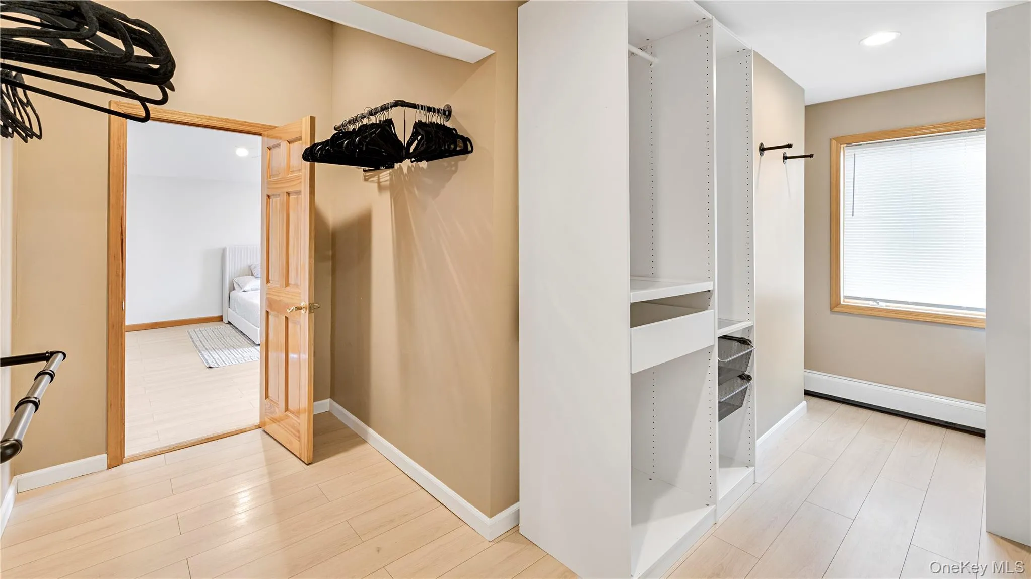 Spacious closet featuring light wood-style flooring Spacious closet featuring light wood-style flooring