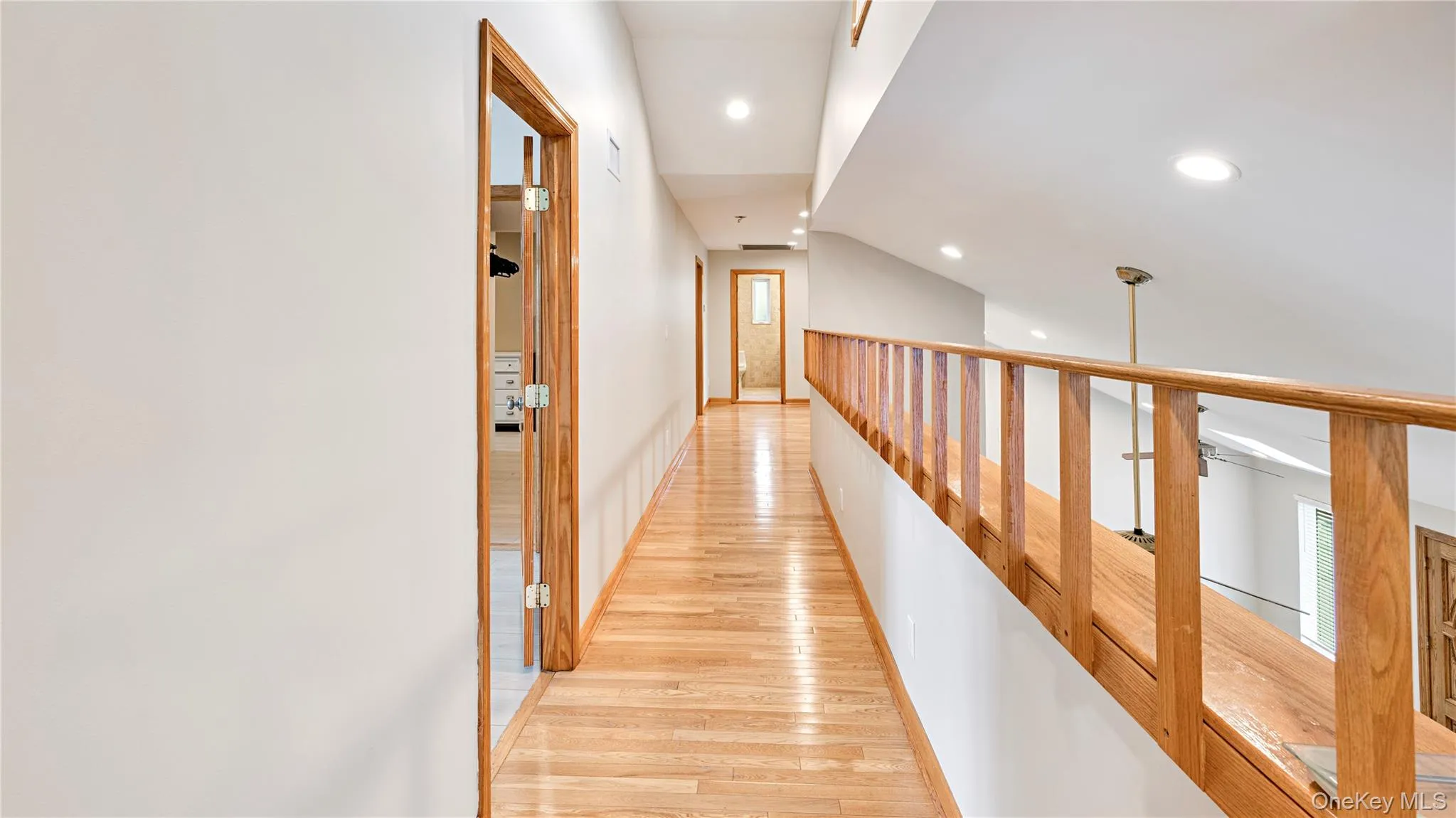 Corridor featuring light wood-style floors and recessed lighting Corridor featuring light wood-style floors and recessed lighting