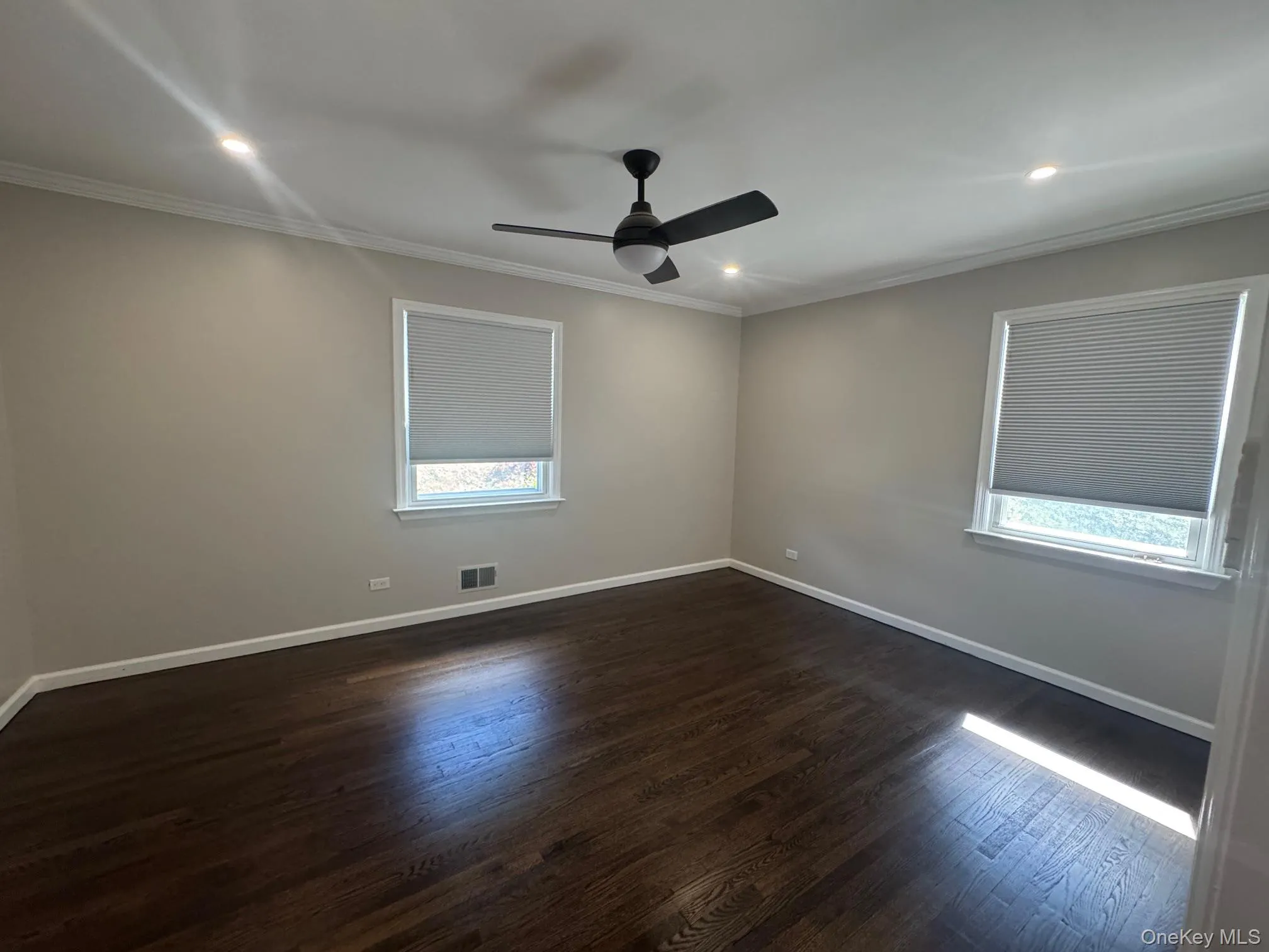 Unfurnished room with dark wood-style flooring, recessed lighting, ornamental molding, and ceiling fan Unfurnished room with dark wood-style flooring, recessed lighting, ornamental molding, and ceiling fan