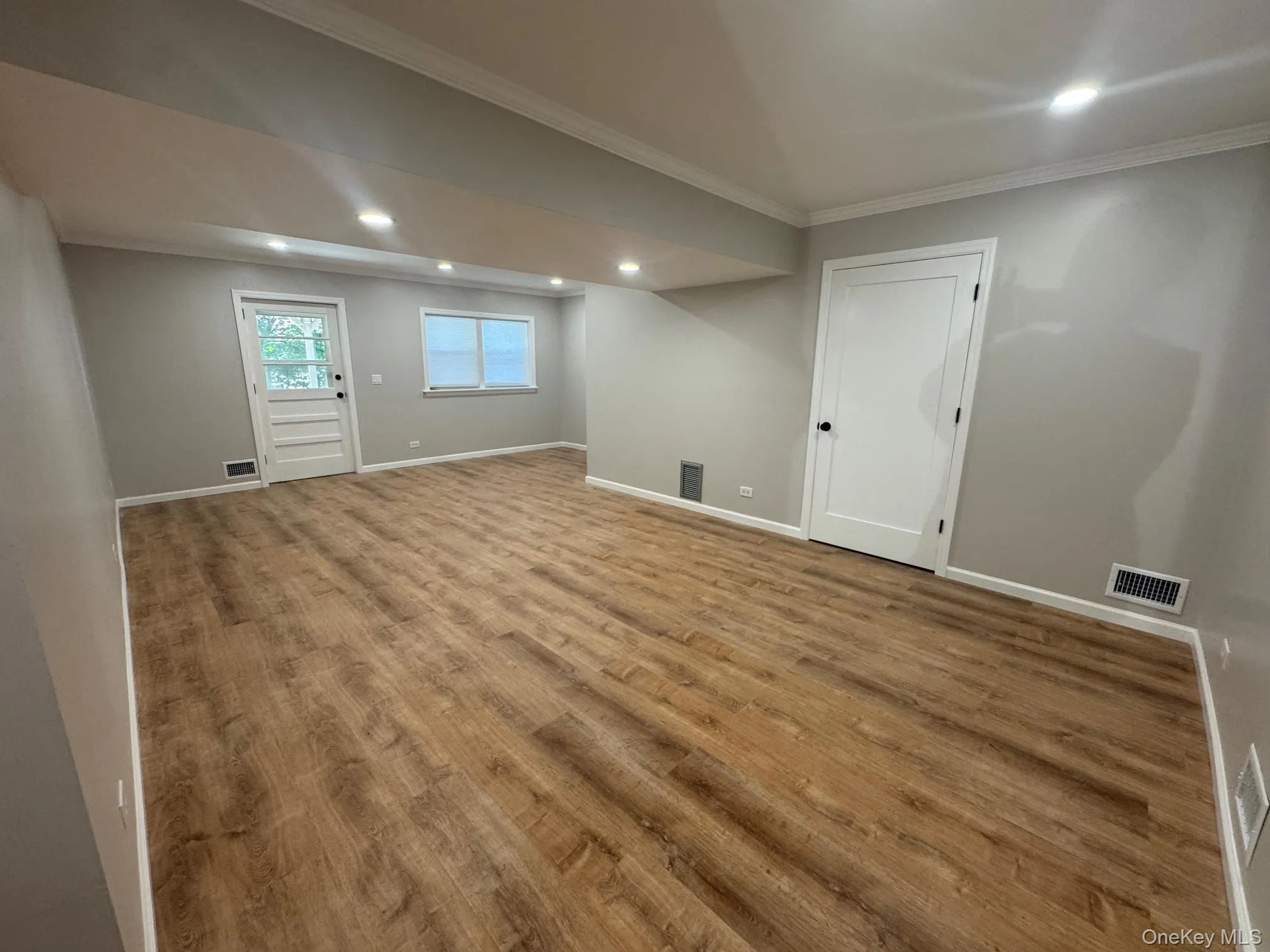 Basement featuring recessed lighting, crown molding, and wood finished floors Basement featuring recessed lighting, crown molding, and wood finished floors