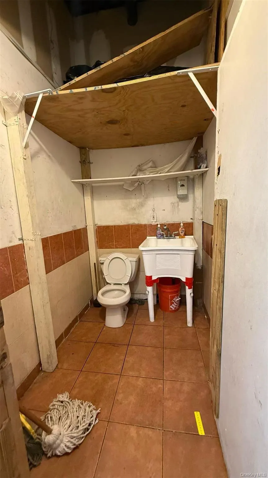 Half bath featuring tile patterned floors and toilet Half bath featuring tile patterned floors and toilet