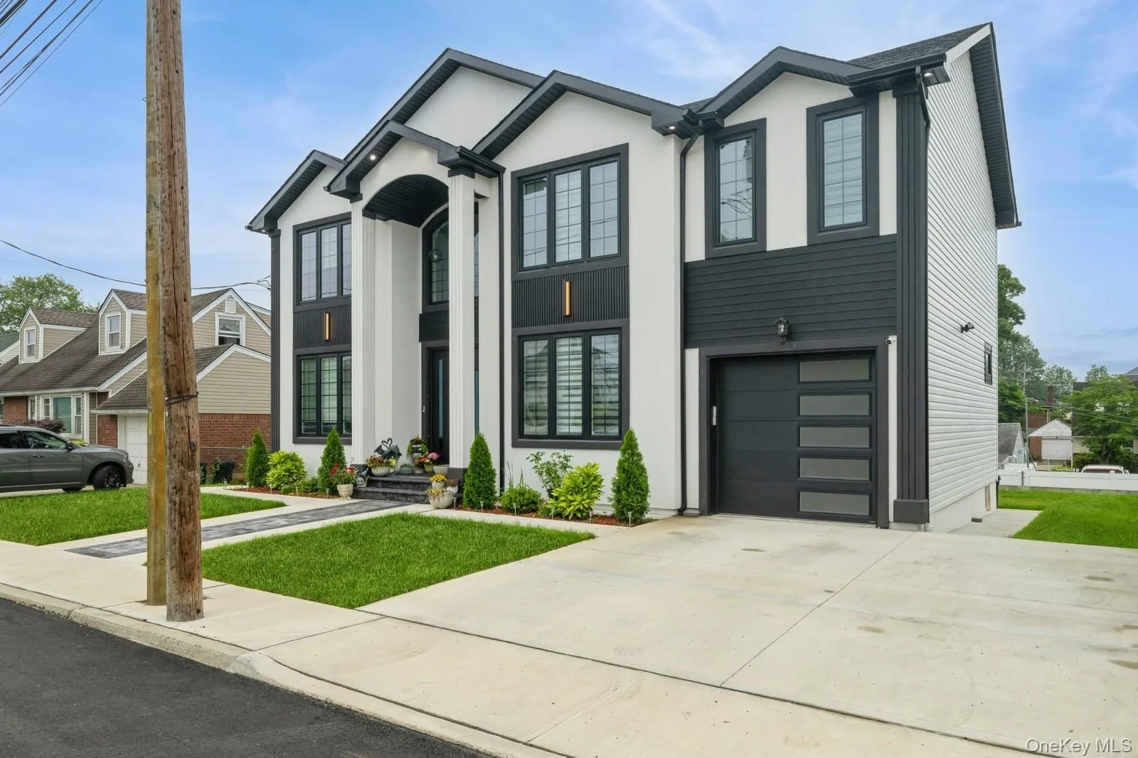 View of front of home featuring driveway, stucco siding, a garage, and a front yard View of front of home featuring driveway, stucco siding, a garage, and a front yard