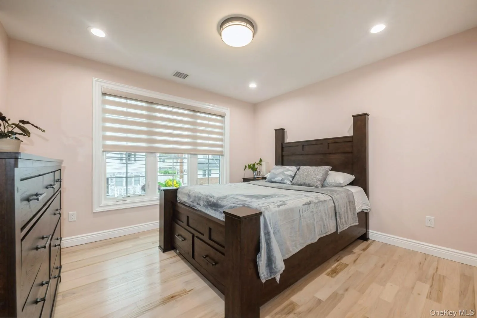 Bedroom with light wood-style floors and recessed lighting Bedroom with light wood-style floors and recessed lighting