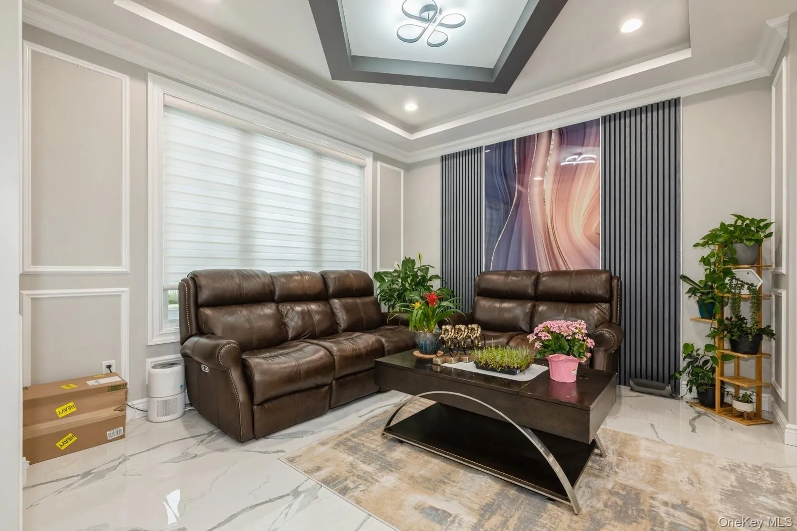 Living room with marble tiled floors, ornamental molding, recessed lighting, and a decorative wall Living room with marble tiled floors, ornamental molding, recessed lighting, and a decorative wall