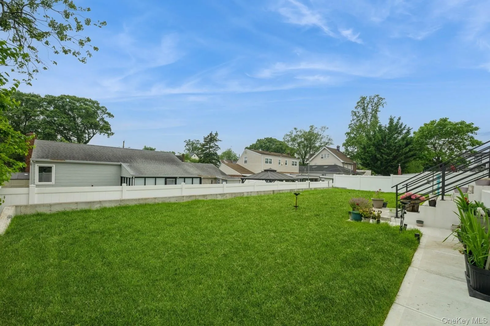 Fenced backyard with a residential view Fenced backyard with a residential view