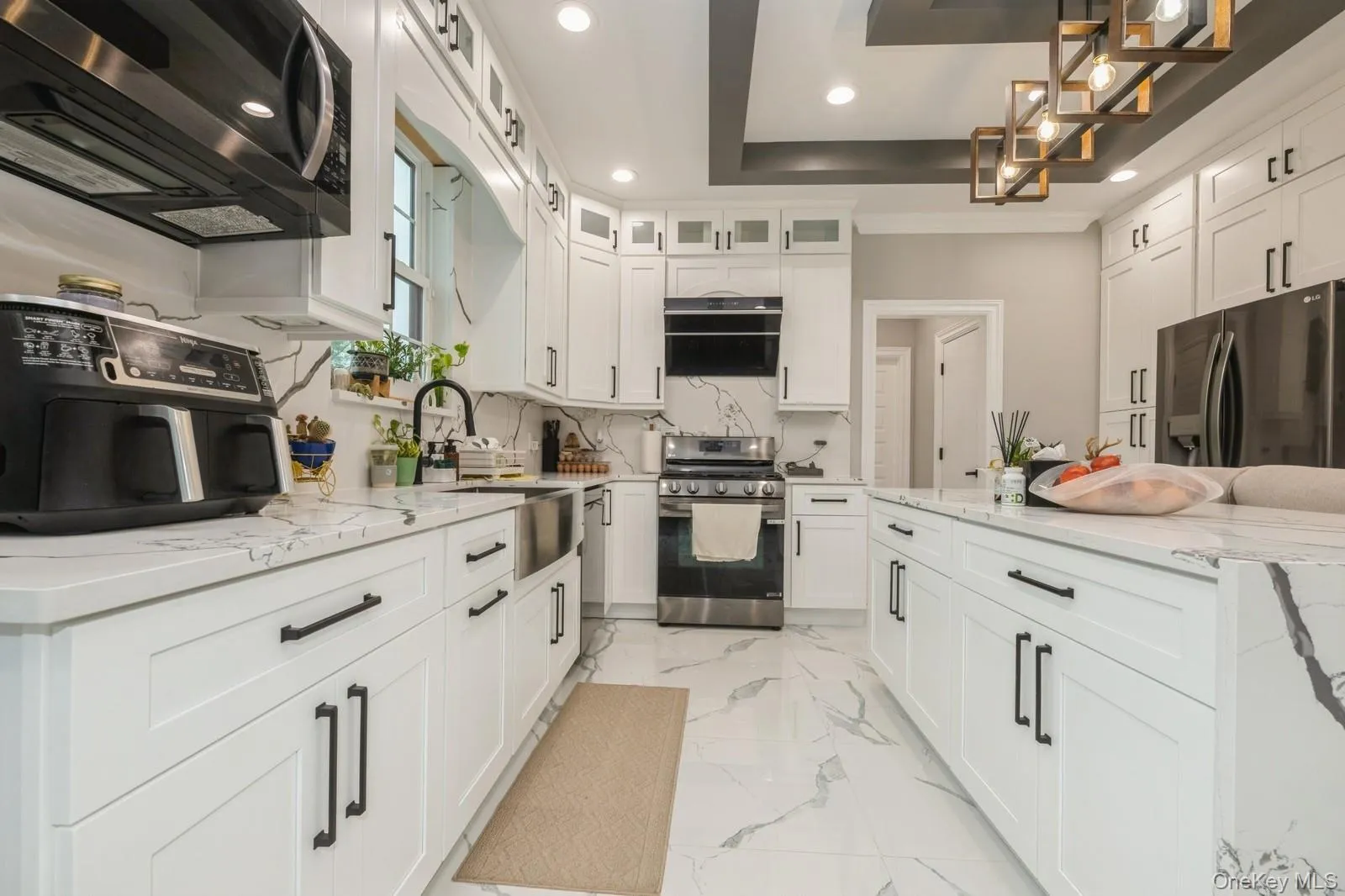 Kitchen featuring light stone counters, white cabinetry, stainless steel appliances, recessed lighting, and a center island Kitchen featuring light stone counters, white cabinetry, stainless steel appliances, recessed lighting, and a center island