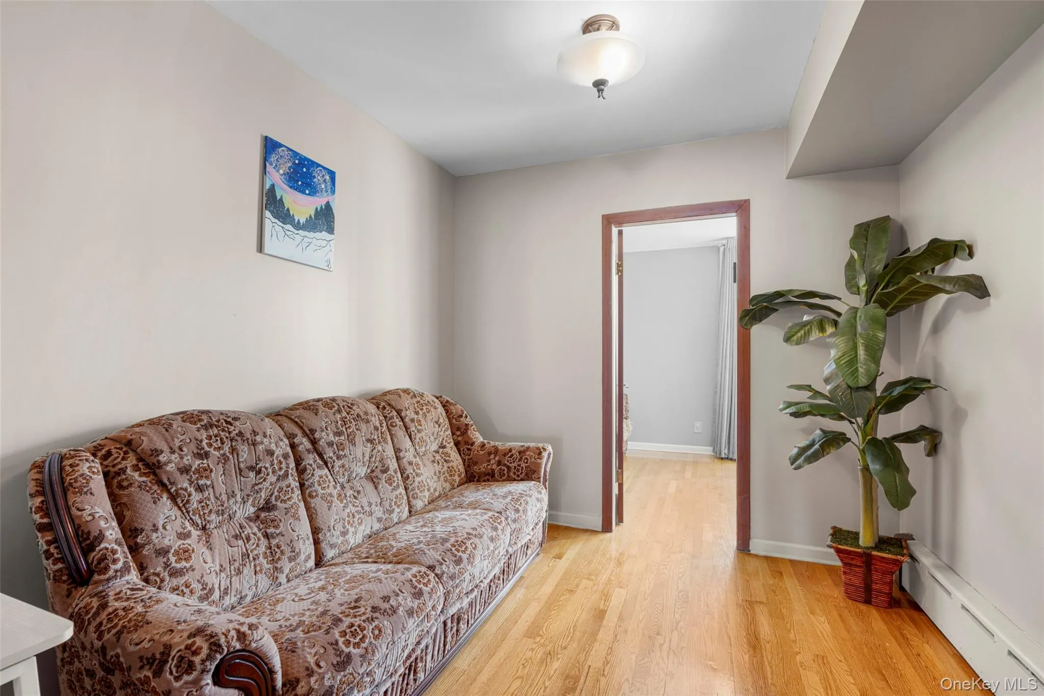 Sitting room with a baseboard radiator and light wood-type flooring Sitting room with a baseboard radiator and light wood-type flooring