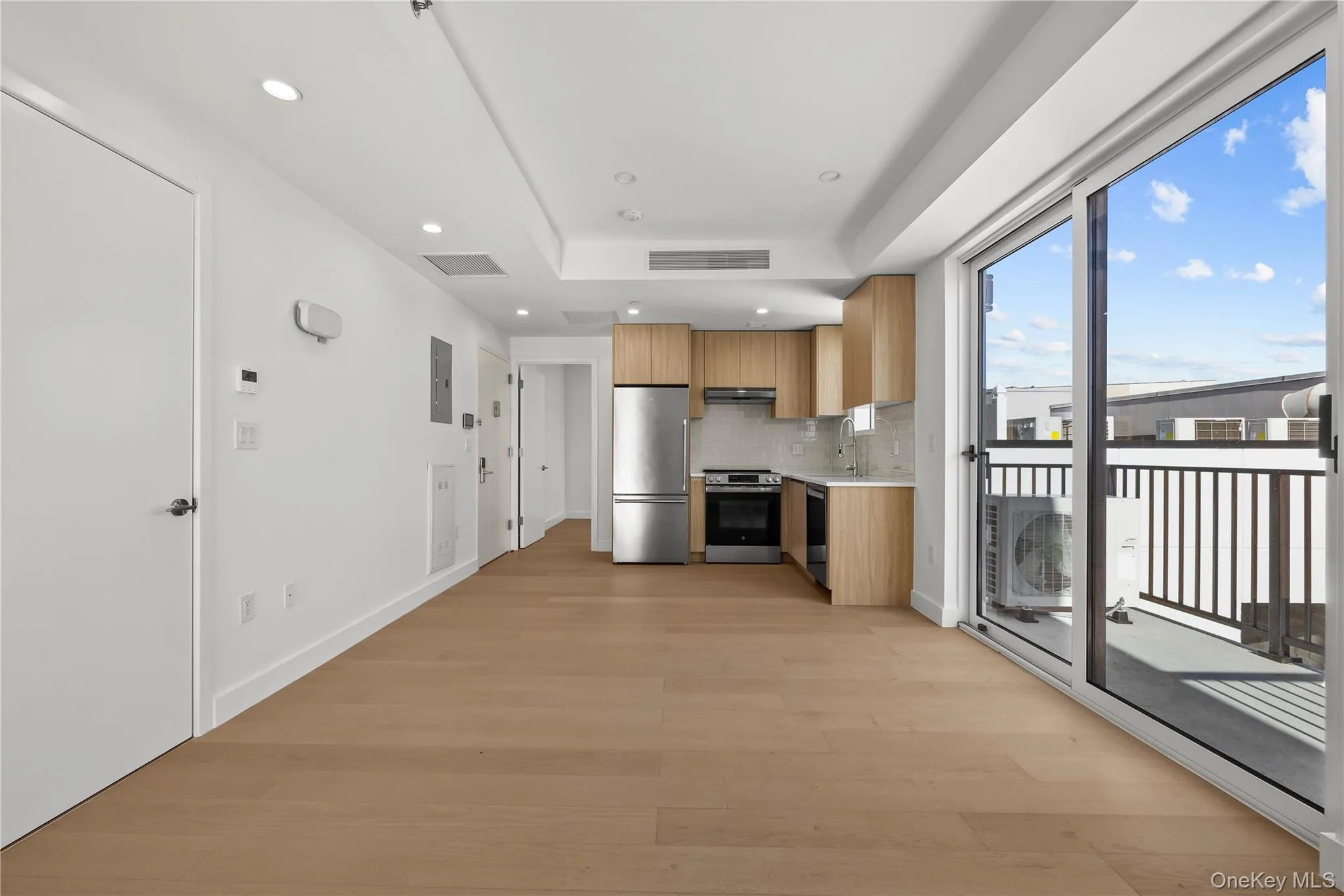 Kitchen with modern cabinets, light countertops, appliances with stainless steel finishes, decorative backsplash, and recessed lighting Kitchen with modern cabinets, light countertops, appliances with stainless steel finishes, decorative backsplash, and recessed lighting
