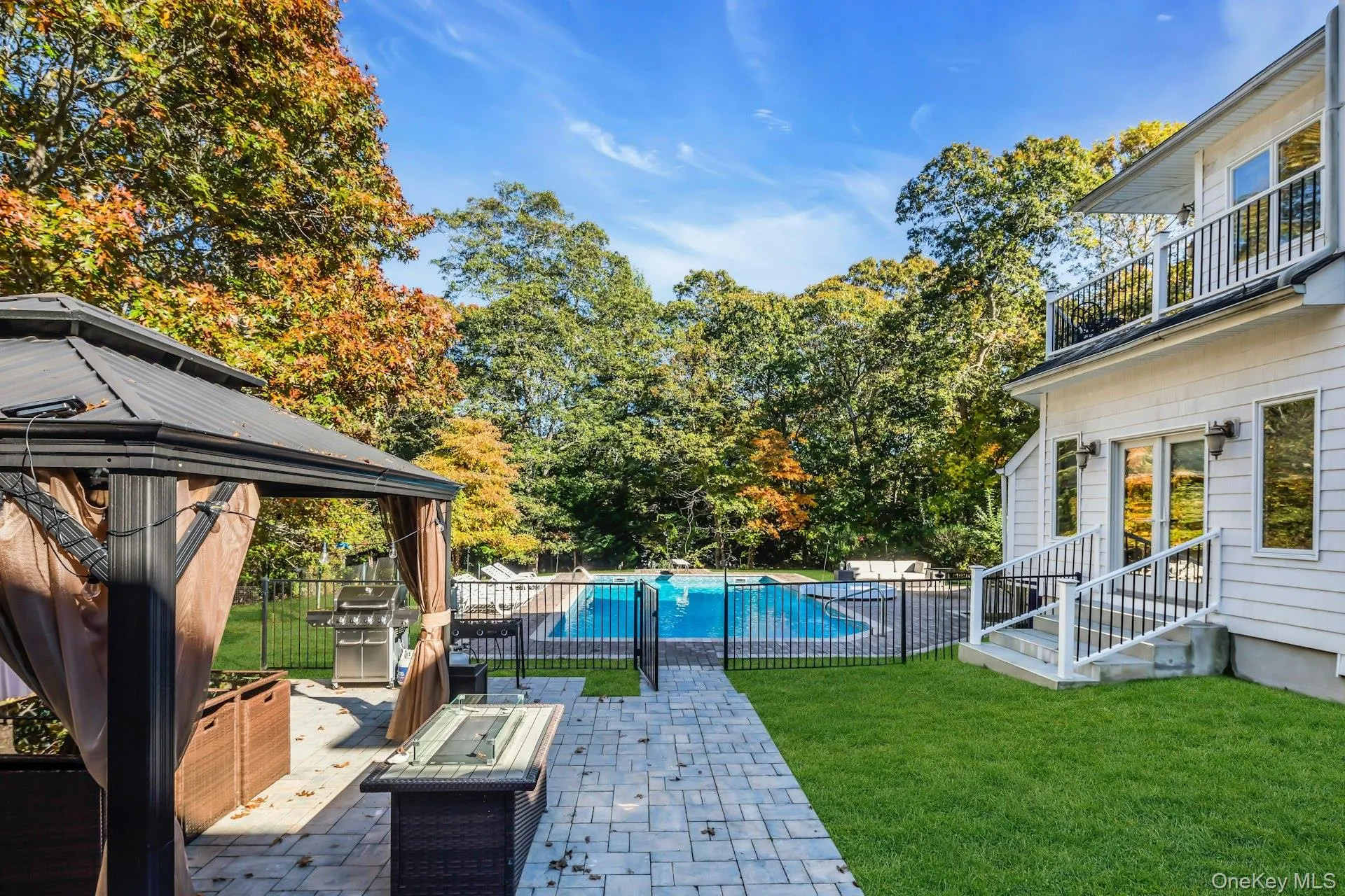 View of yard featuring a patio, a balcony, a gazebo, a fire pit, and view of wooded area