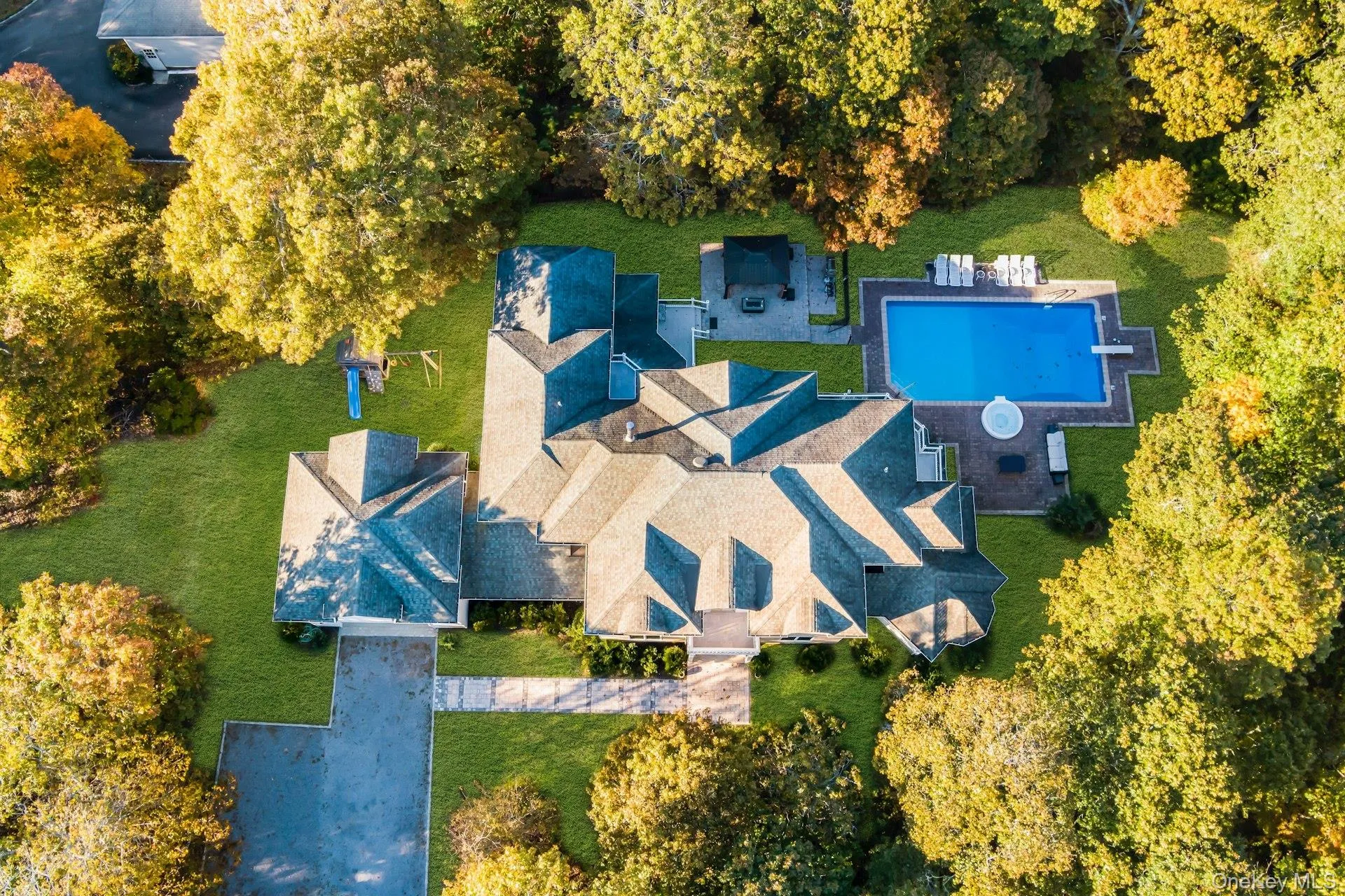 Aerial view of property and surrounding area featuring a pool