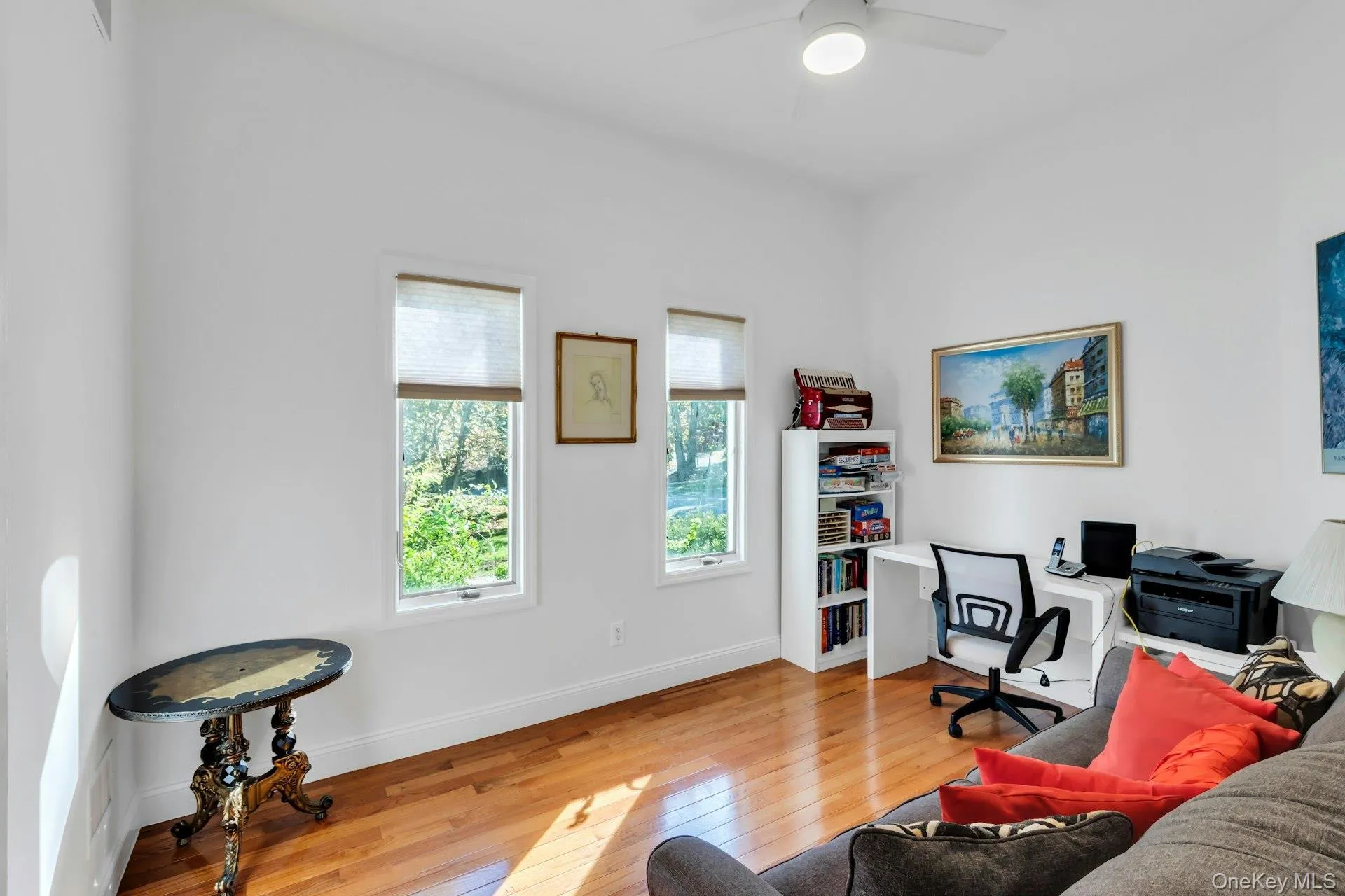 Home office with light wood-style floors and ceiling fan