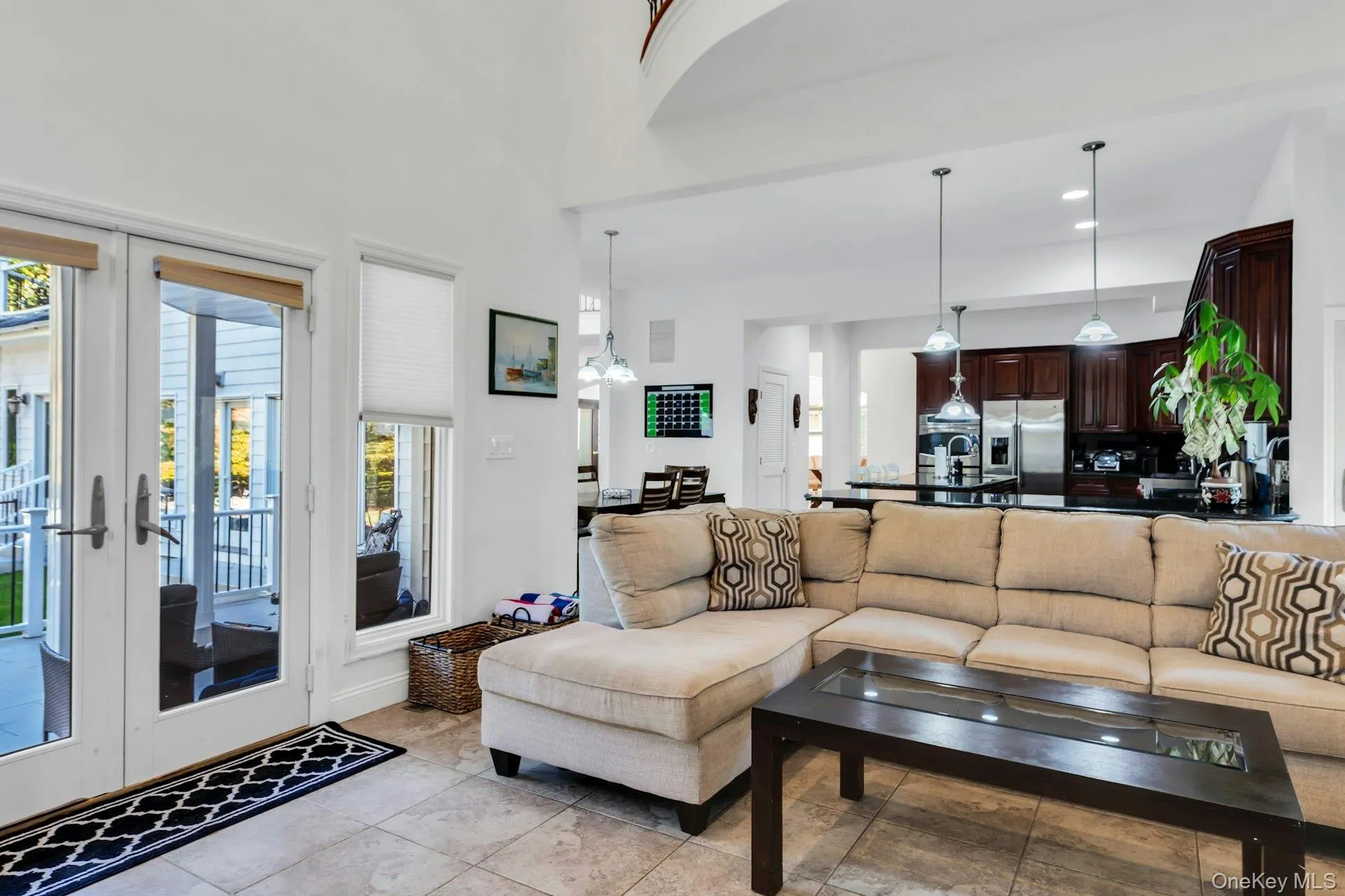 Living room featuring french doors, recessed lighting, a high ceiling, and light tile patterned floors