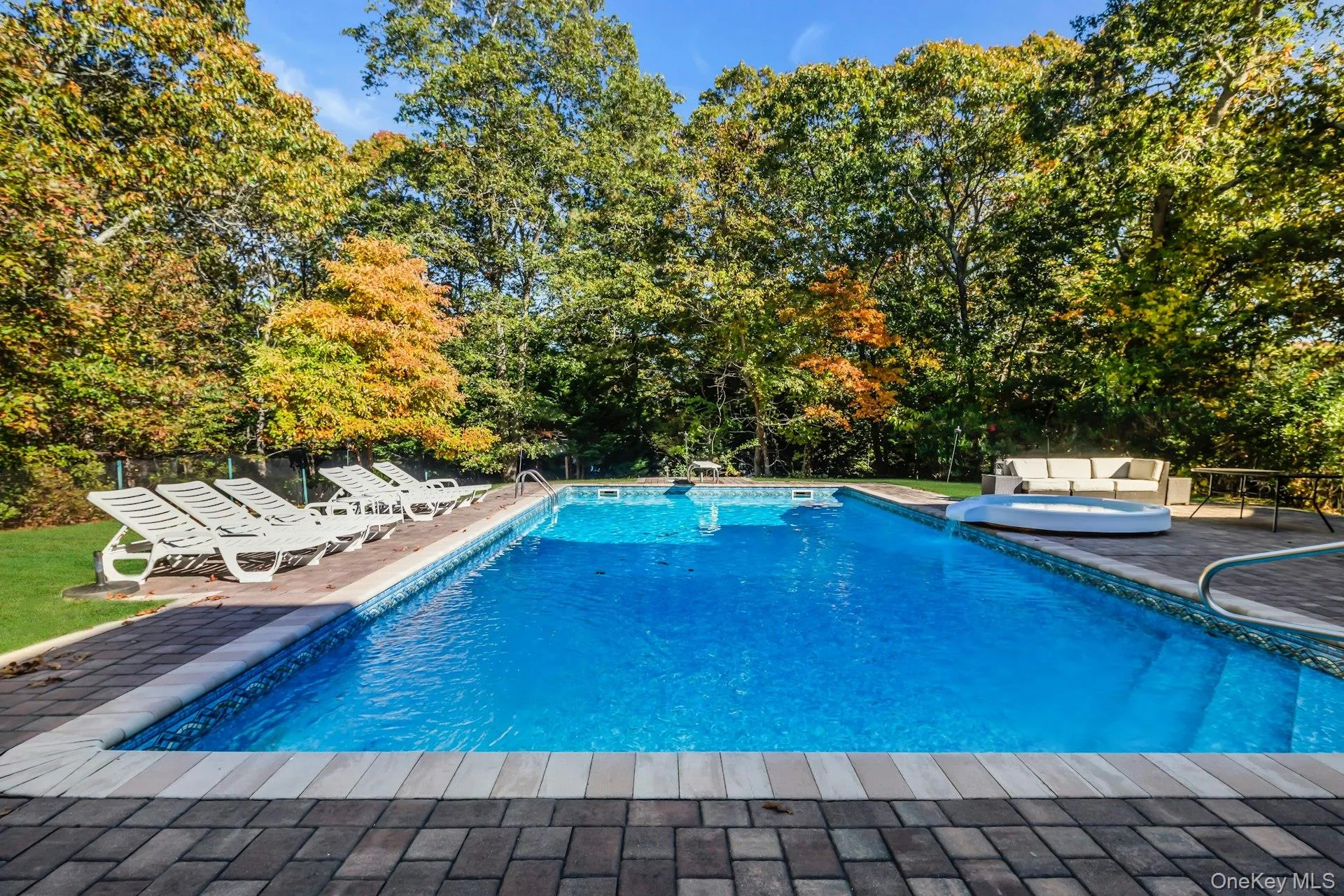View of swimming pool with a patio and a pool with connected hot tub