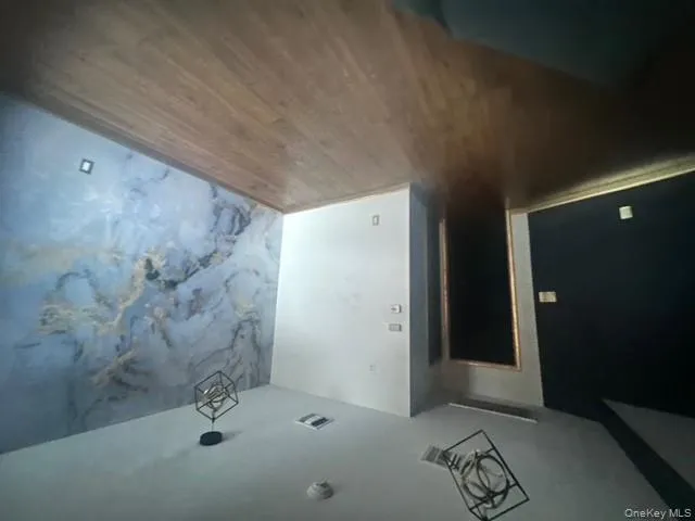 Spare room with wood finished floors and an accent wall Spare room with wood finished floors and an accent wall