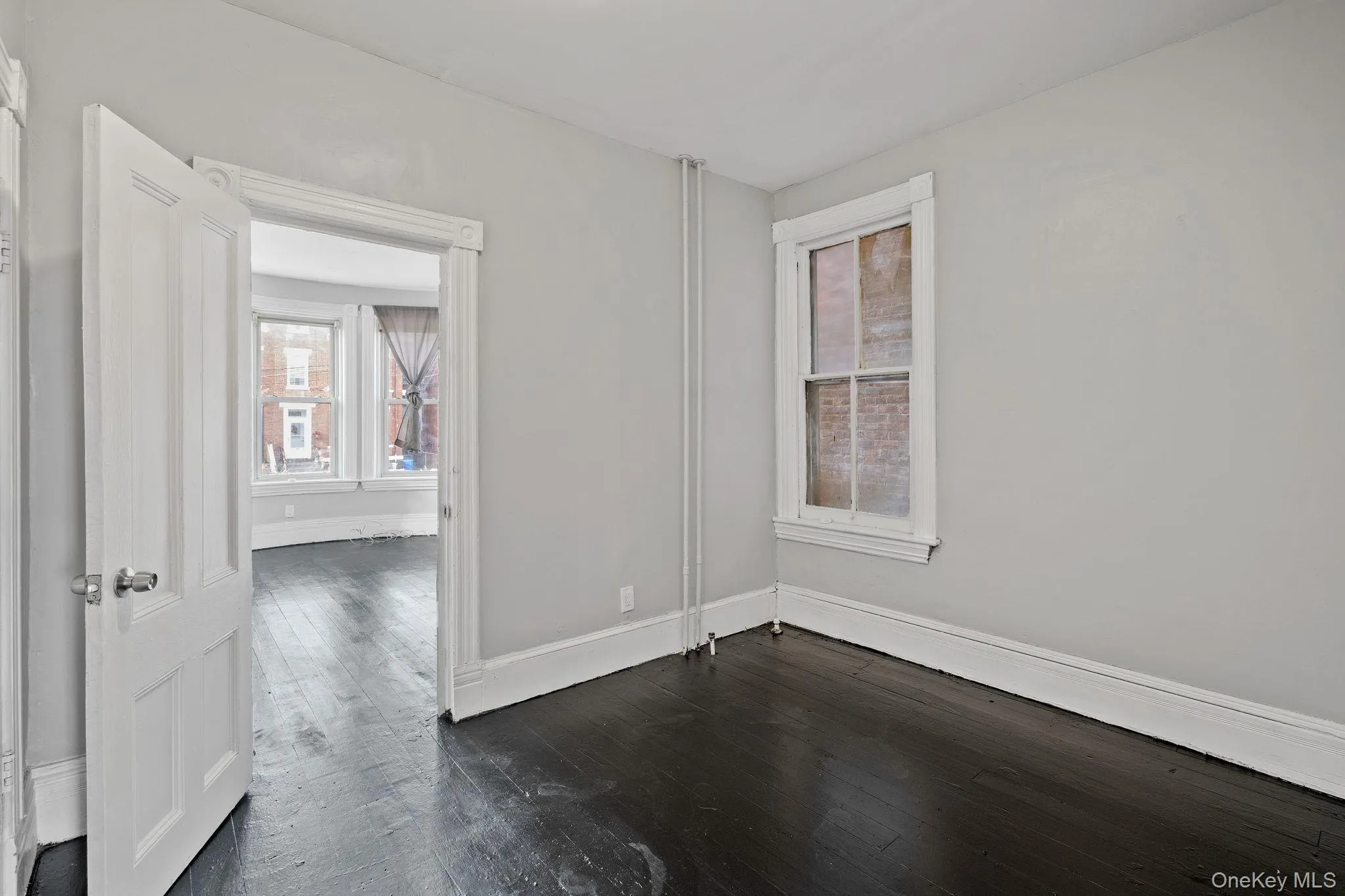 Empty room with baseboards and dark wood-style floors Empty room with baseboards and dark wood-style floors
