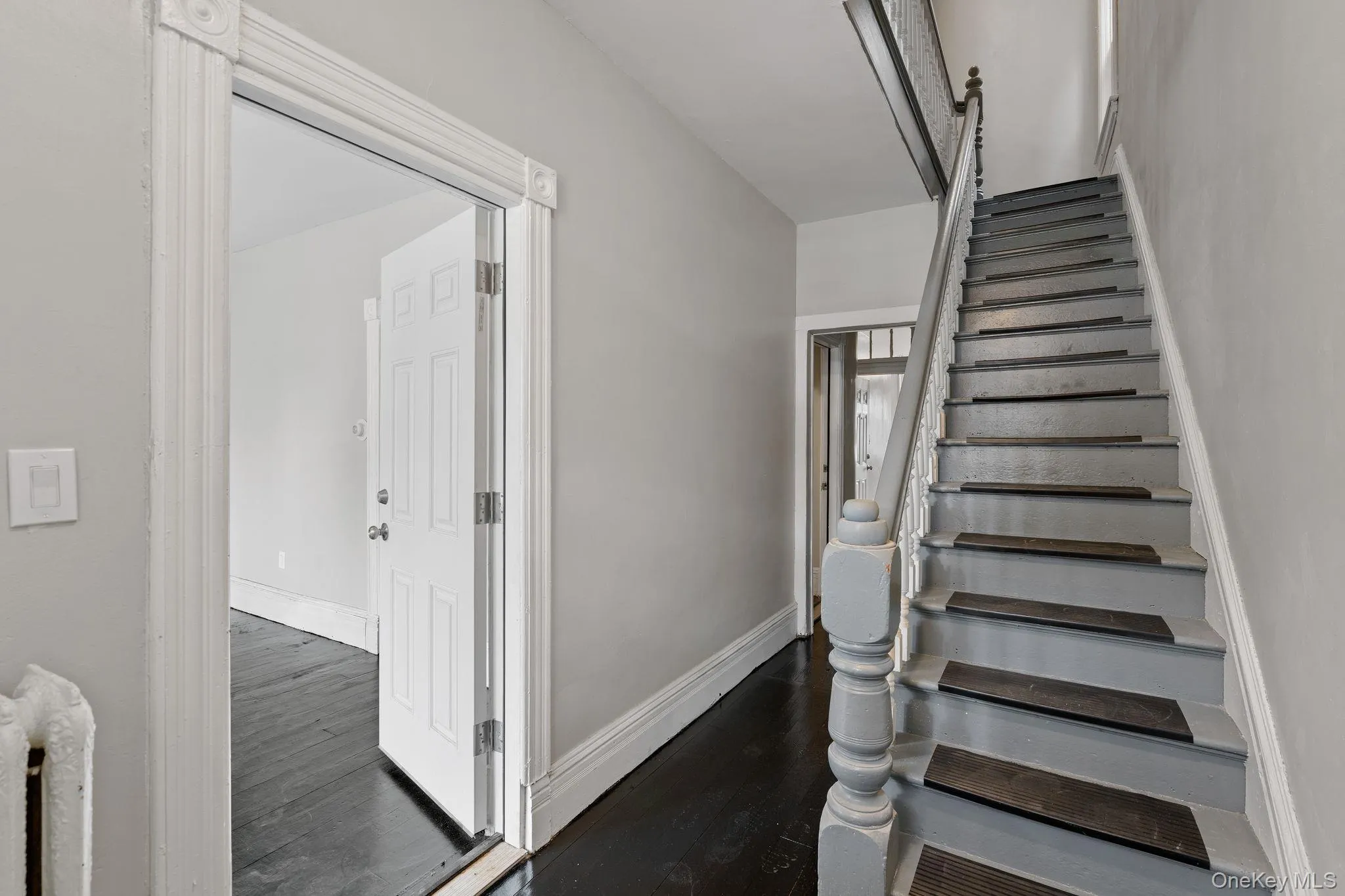 Stairs featuring wood finished floors and radiator Stairs featuring wood finished floors and radiator