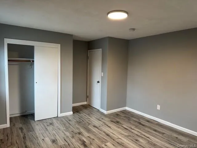 Unfurnished bedroom with a closet and wood finished floors Unfurnished bedroom with a closet and wood finished floors