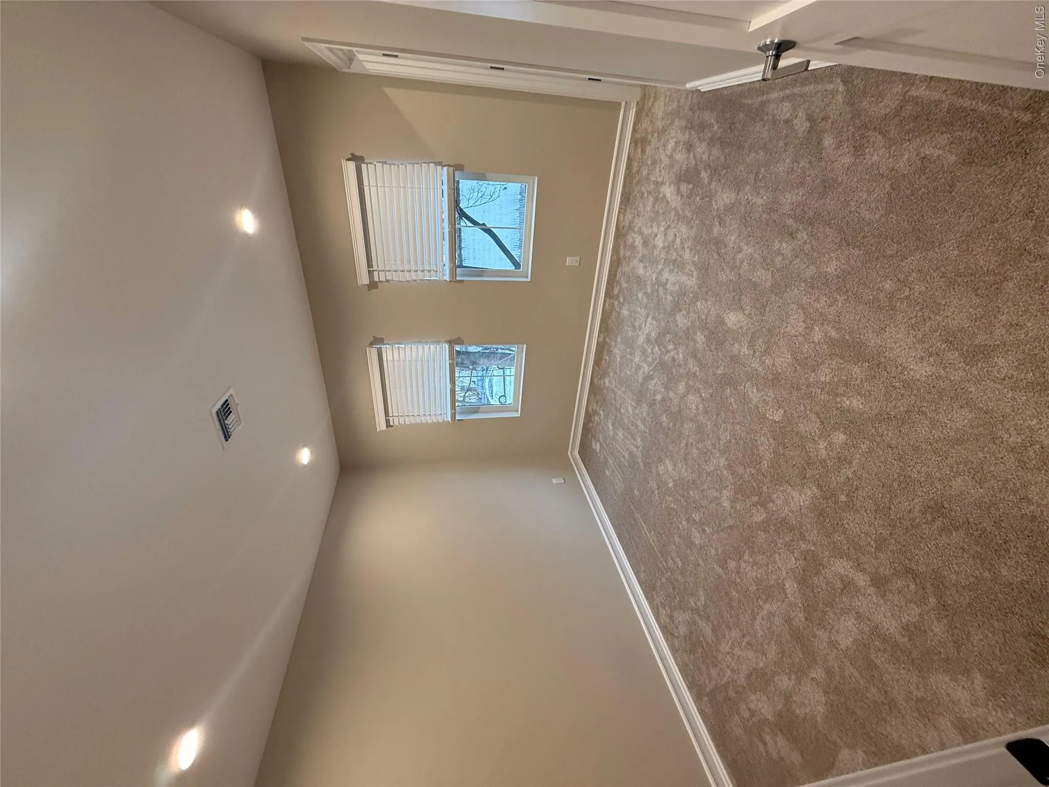 Spare room featuring recessed lighting and dark colored carpet Spare room featuring recessed lighting and dark colored carpet