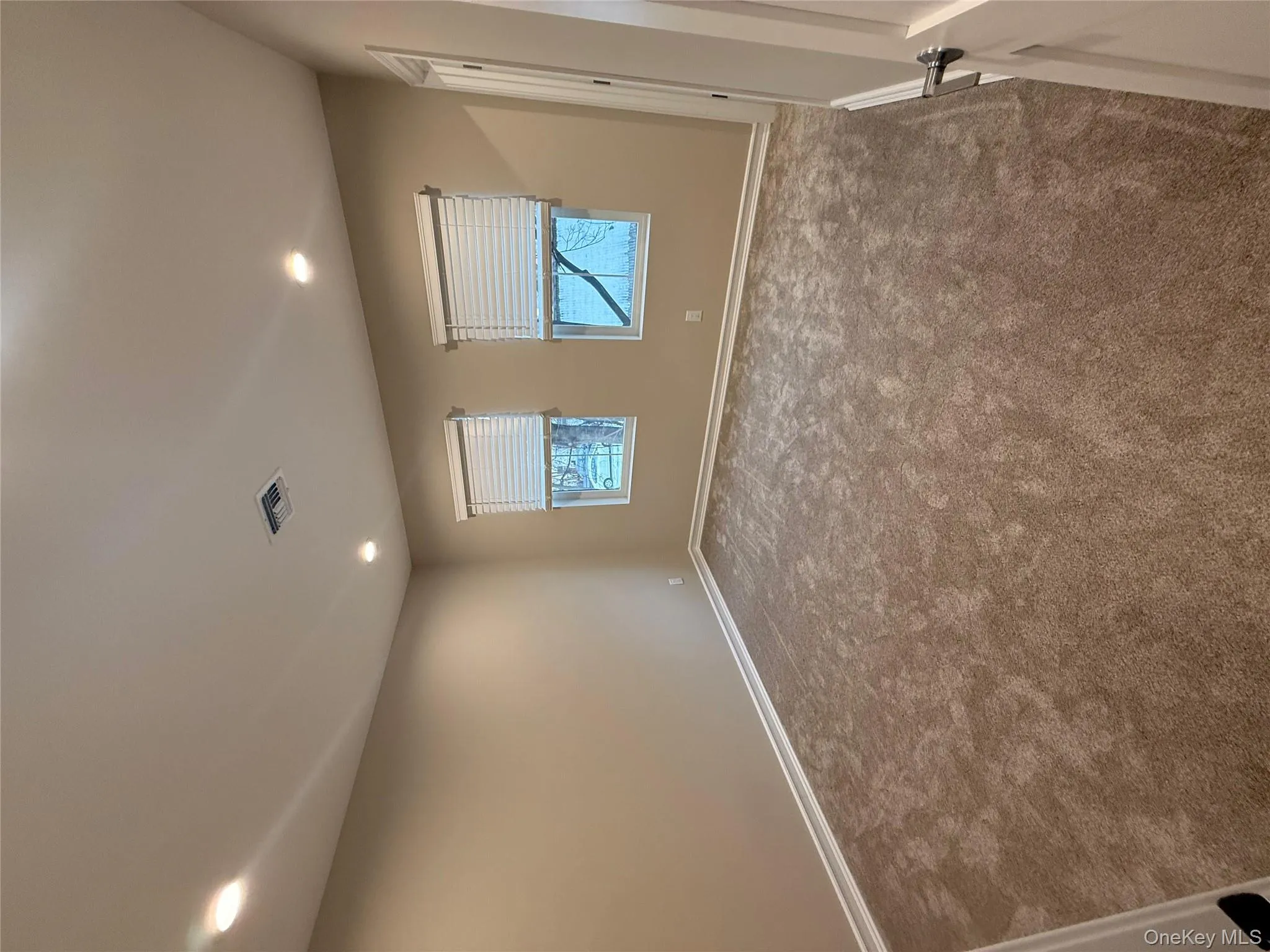 Spare room featuring recessed lighting and dark colored carpet Spare room featuring recessed lighting and dark colored carpet